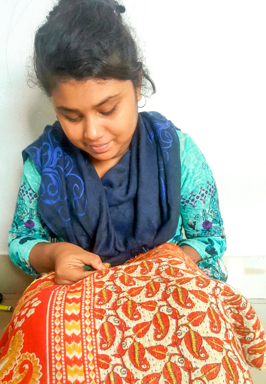 Upcycled sari clutch featuring vibrant colors and intricate kantha stitch embroidery, perfect for carrying essentials.