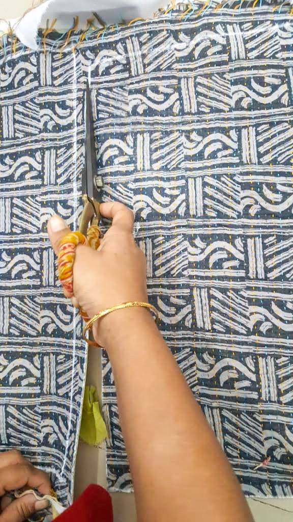 Upcycled sari clutch featuring vibrant colors and intricate kantha stitch embroidery, perfect for carrying essentials.