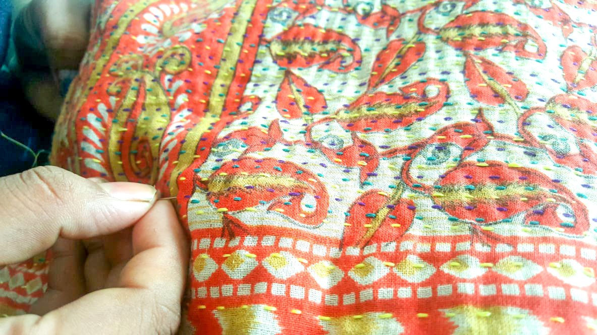 Upcycled sari clutch featuring vibrant colors and intricate kantha stitch embroidery, perfect for carrying essentials.