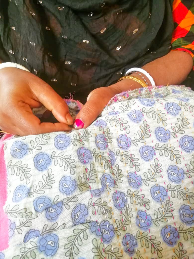 Upcycled sari clutch featuring vibrant colors and intricate kantha stitch embroidery, perfect for carrying essentials.