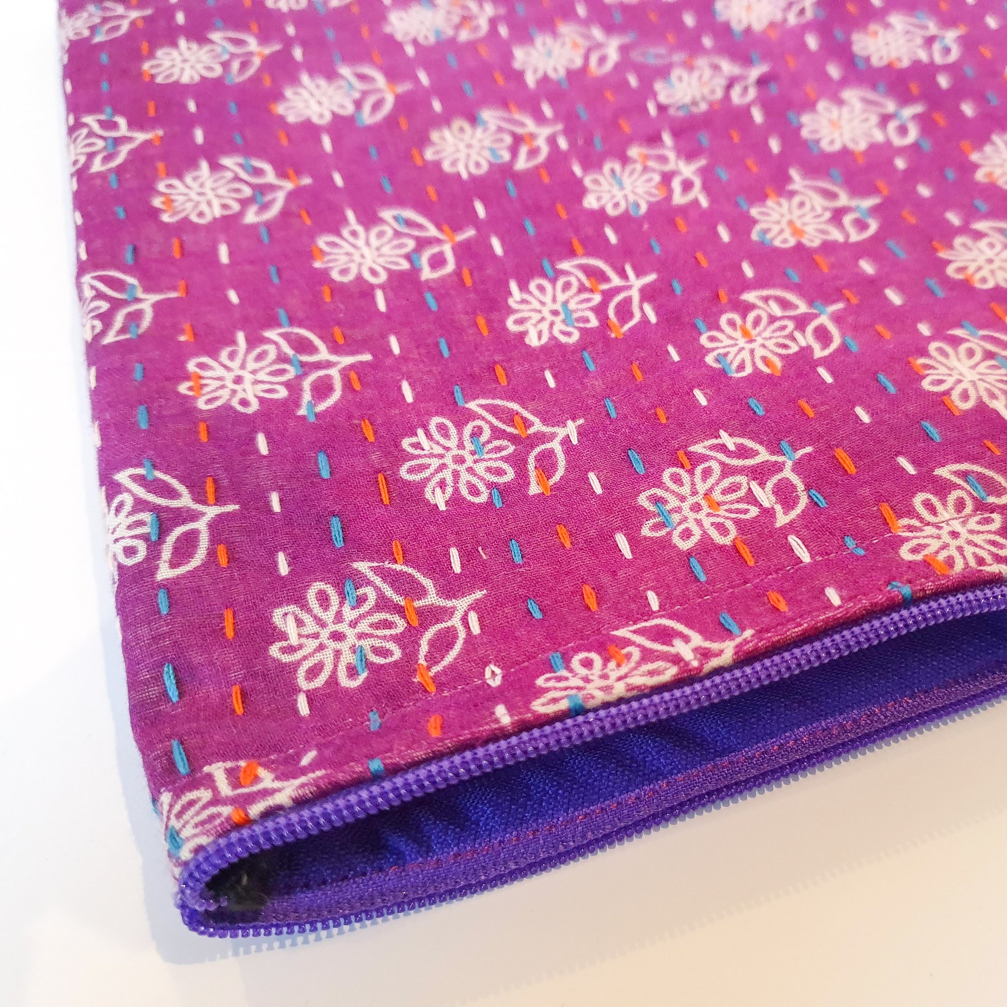 Upcycled sari clutch featuring vibrant colors and intricate kantha stitch embroidery, perfect for carrying essentials.