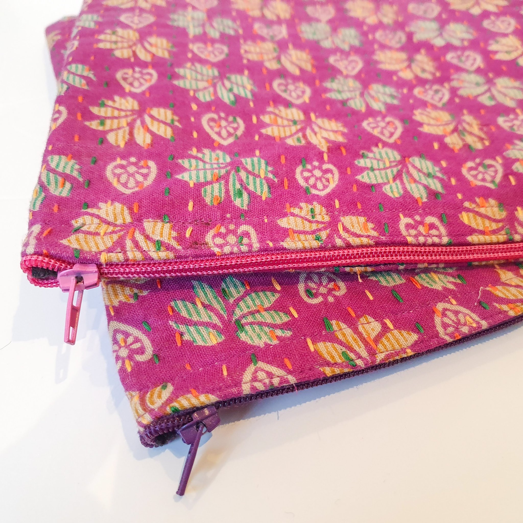 Upcycled sari clutch featuring vibrant colors and intricate kantha stitch embroidery, perfect for carrying essentials.