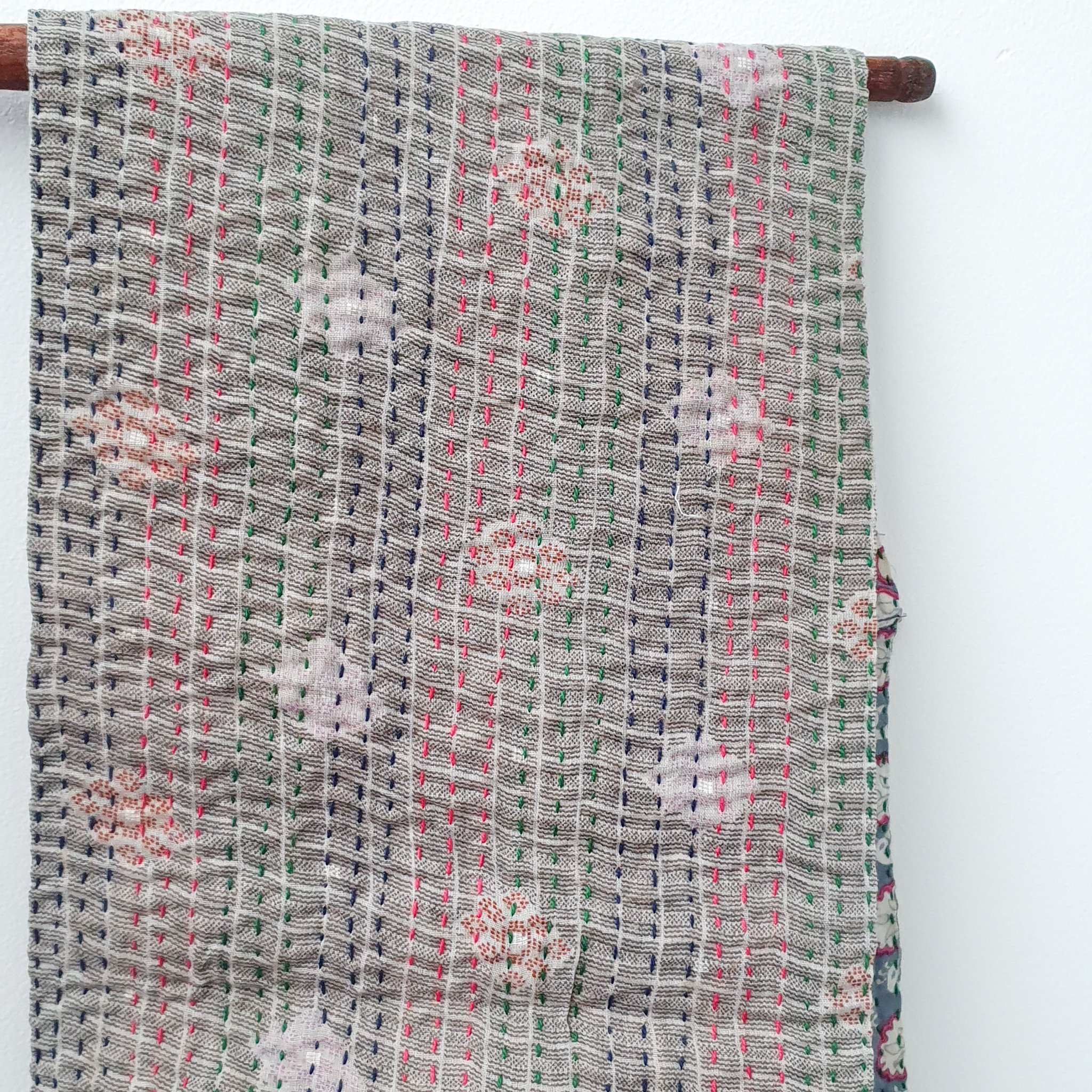 A vibrant upcycled sari cotton kantha infinity scarf showcasing unique patterns and colors, hand-stitched with traditional kantha technique.