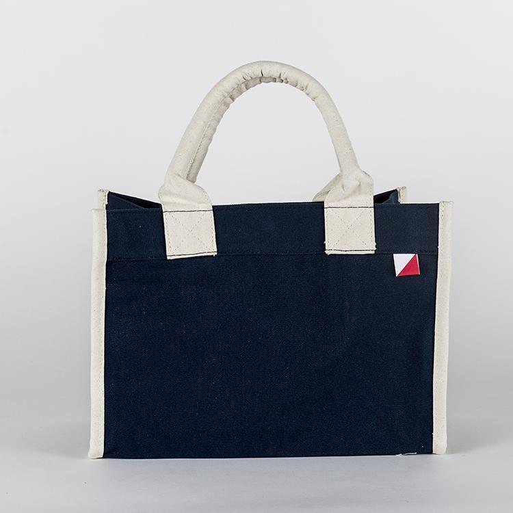 Village Tote Bag with rolled canvas handles and structured design, featuring three interior pockets for organization.