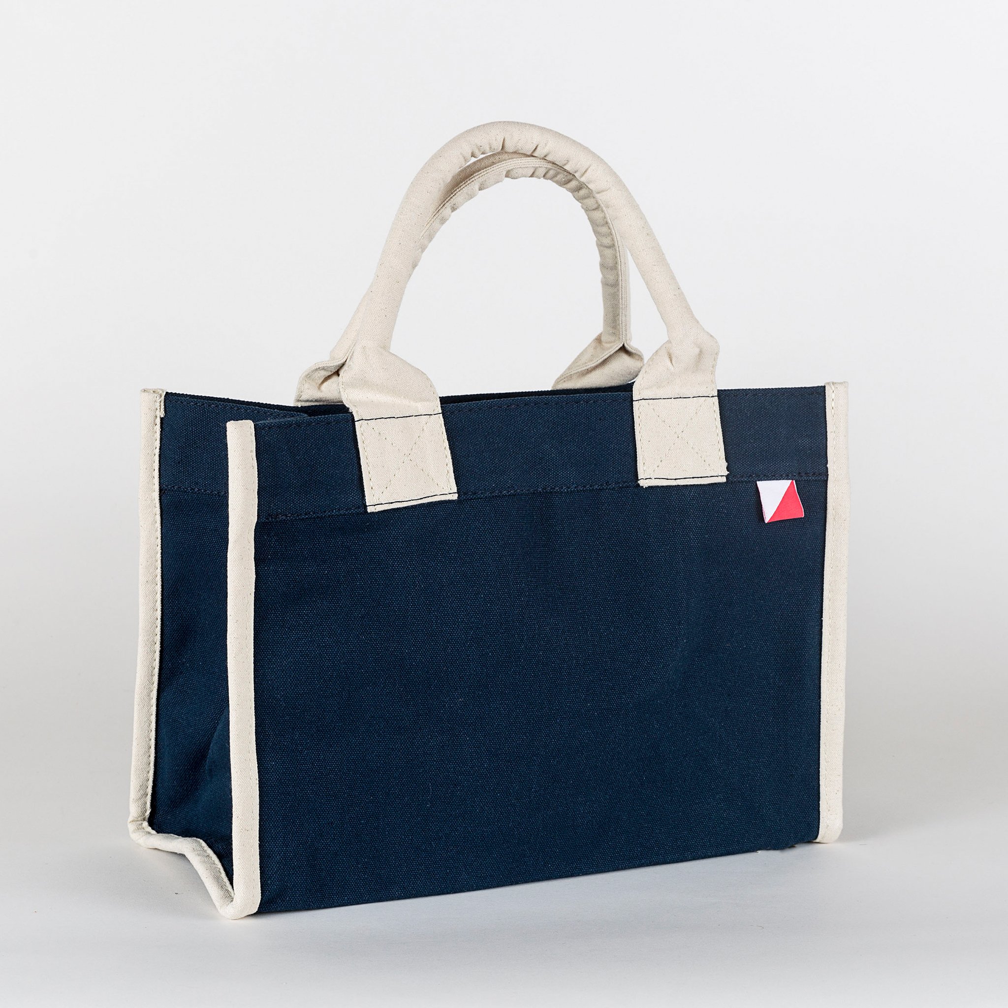 Village Tote Bag with rolled canvas handles and structured design, featuring three interior pockets for organization.