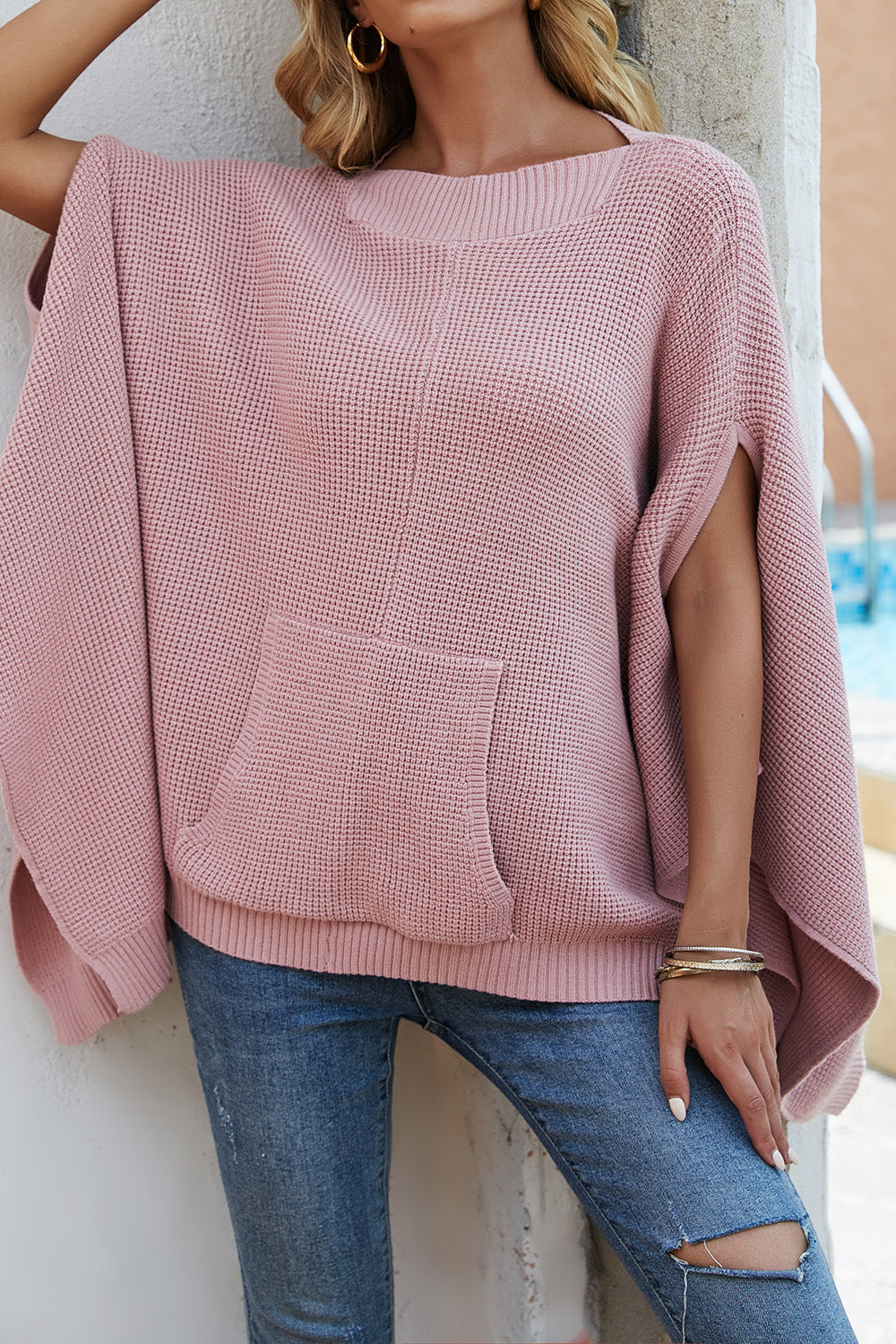 Waffle-Knit Pocketed Cape Sleeve Sweater in a cozy design with pockets, showcasing its stylish waffle texture and relaxed fit.