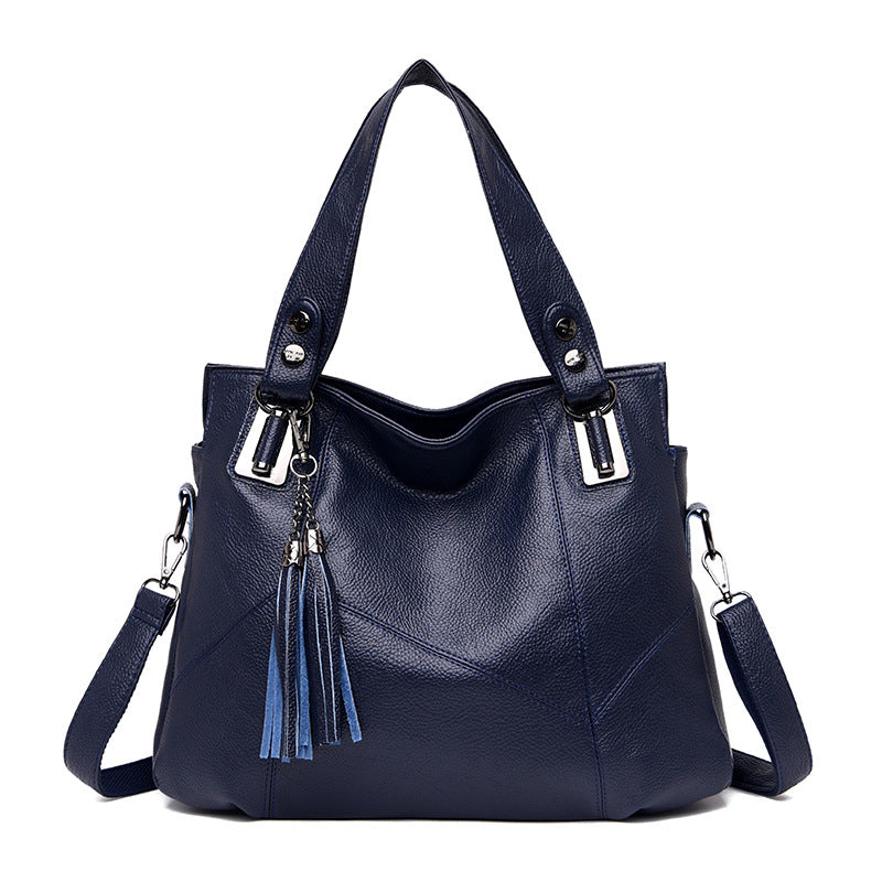 A stylish Women's Large Capacity Fringed Shoulder Handbag made from composite cowhide, featuring tassel accents and a spacious interior.
