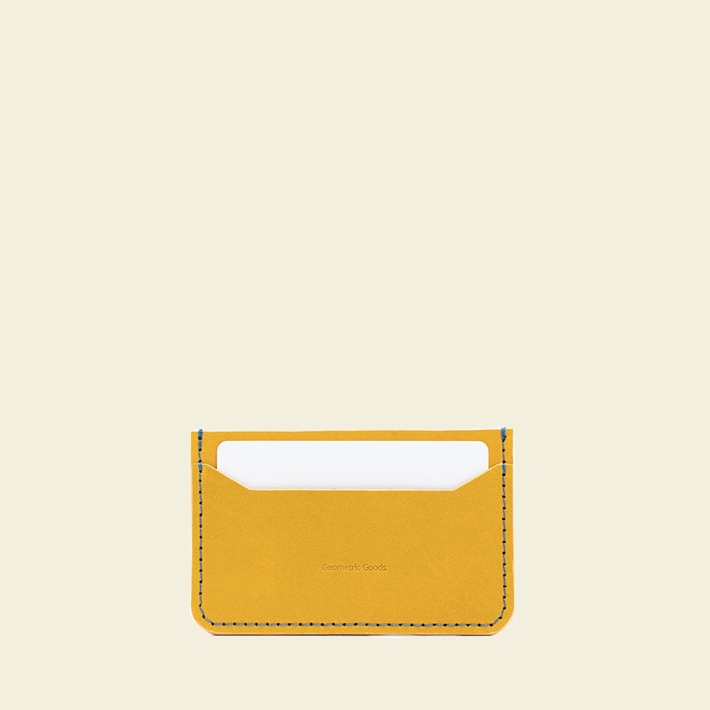 A stylish yellow and blue leather card holder, handcrafted from premium vegetable-tanned leather, showcasing its sleek design and durability.