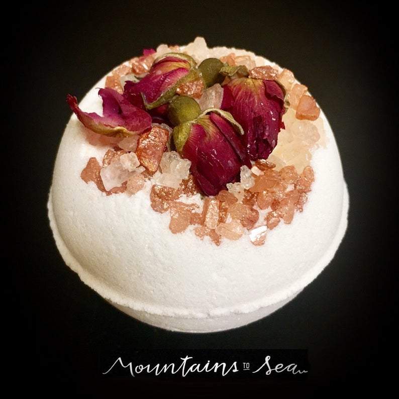 Artisan Wild Rose Petal Vegan Bath Bomb with whole rose buds and petals, showcasing its vibrant colors and luxurious texture.