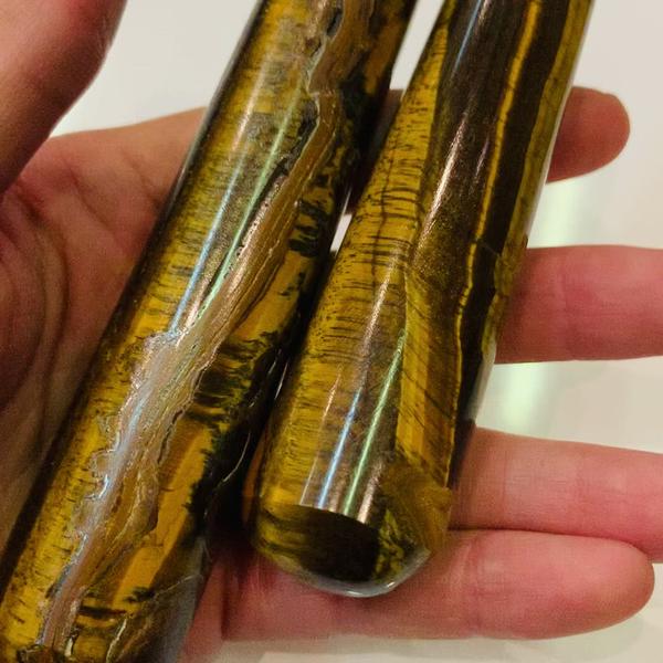 Bâton de massage en œil de tigre, pierre naturelle avec des couleurs chatoyantes, idéal pour la relaxation et l'équilibre émotionnel.