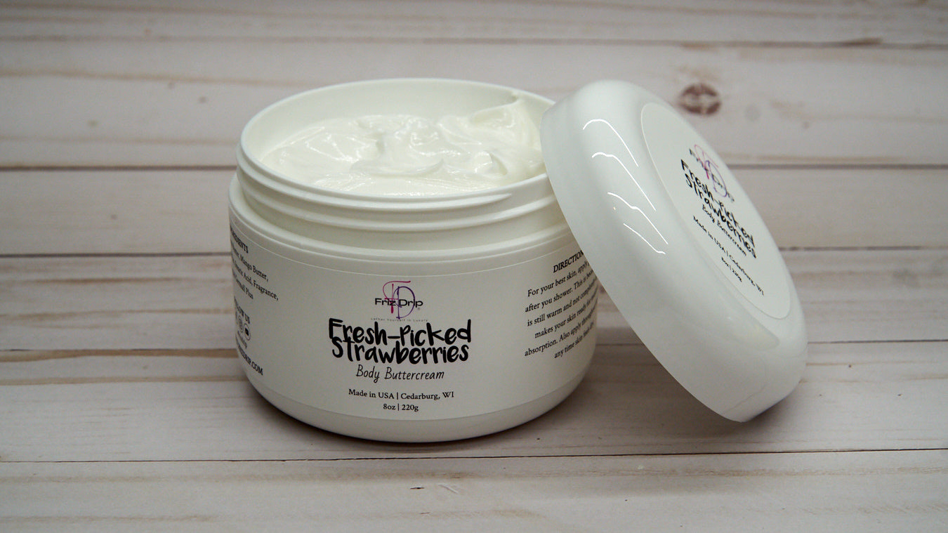 A jar of Fresh-Picked Strawberries Body Cream with a vibrant strawberry design, showcasing its creamy texture and fruity scent.