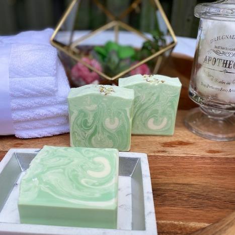 Lemongrass soap bar with essential oils, showcasing its creamy texture and vibrant color, placed on a natural wooden surface.