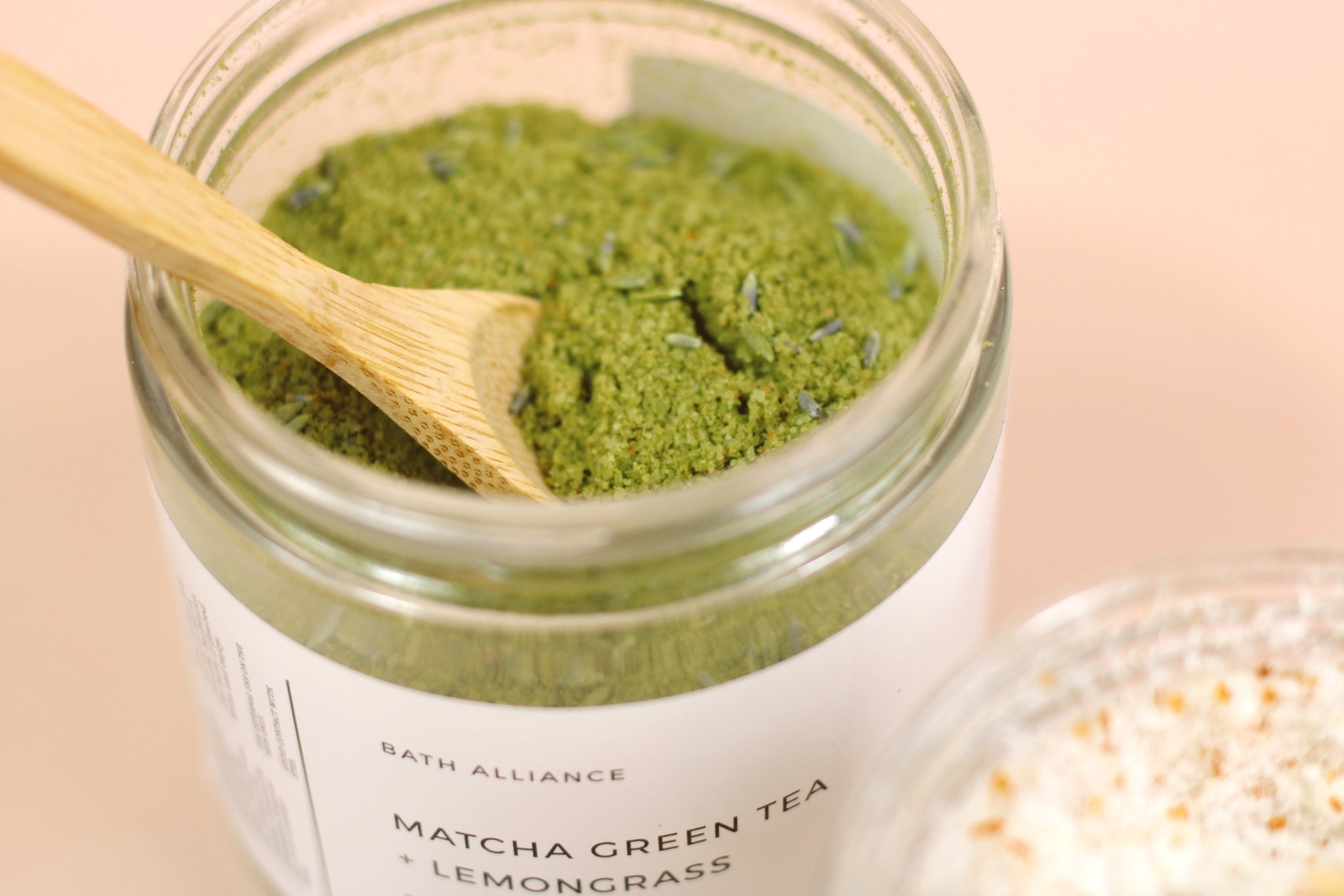 A jar of Matcha Green Tea + Lemongrass Bath Soak with natural ingredients, perfect for relaxation and skin nourishment.