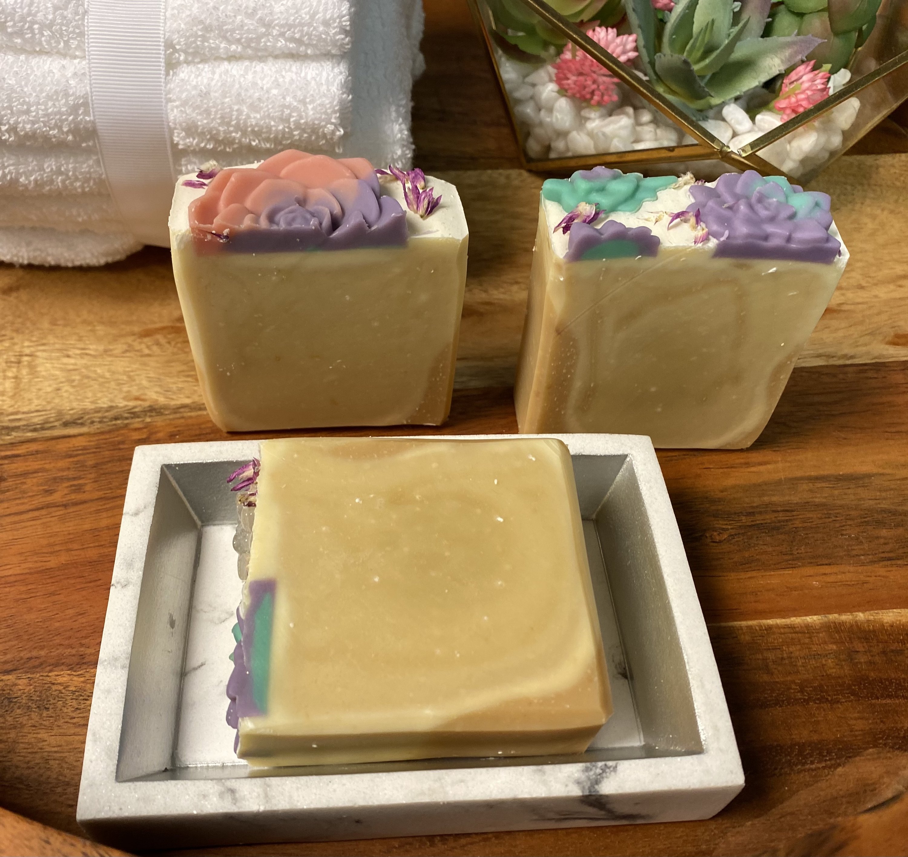 A bar of Soothing Goats Milk Peach Succulent Soap with a creamy texture and peach color, ideal for sensitive skin.