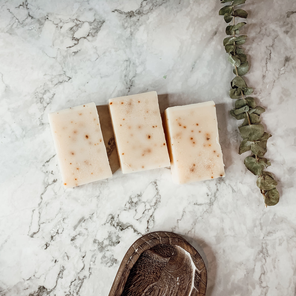 A bar of Tea Tree Mint soap featuring a blend of tea tree oil and peppermint leaves, showcasing its natural colors and texture.