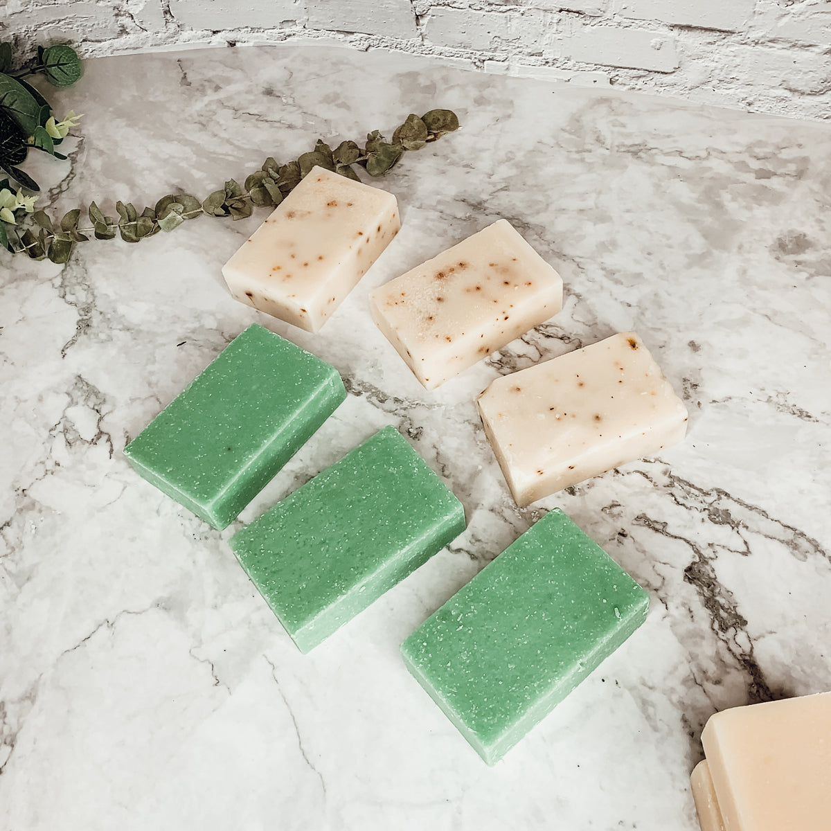 A bar of Tea Tree Mint soap featuring a blend of tea tree oil and peppermint leaves, showcasing its natural colors and texture.
