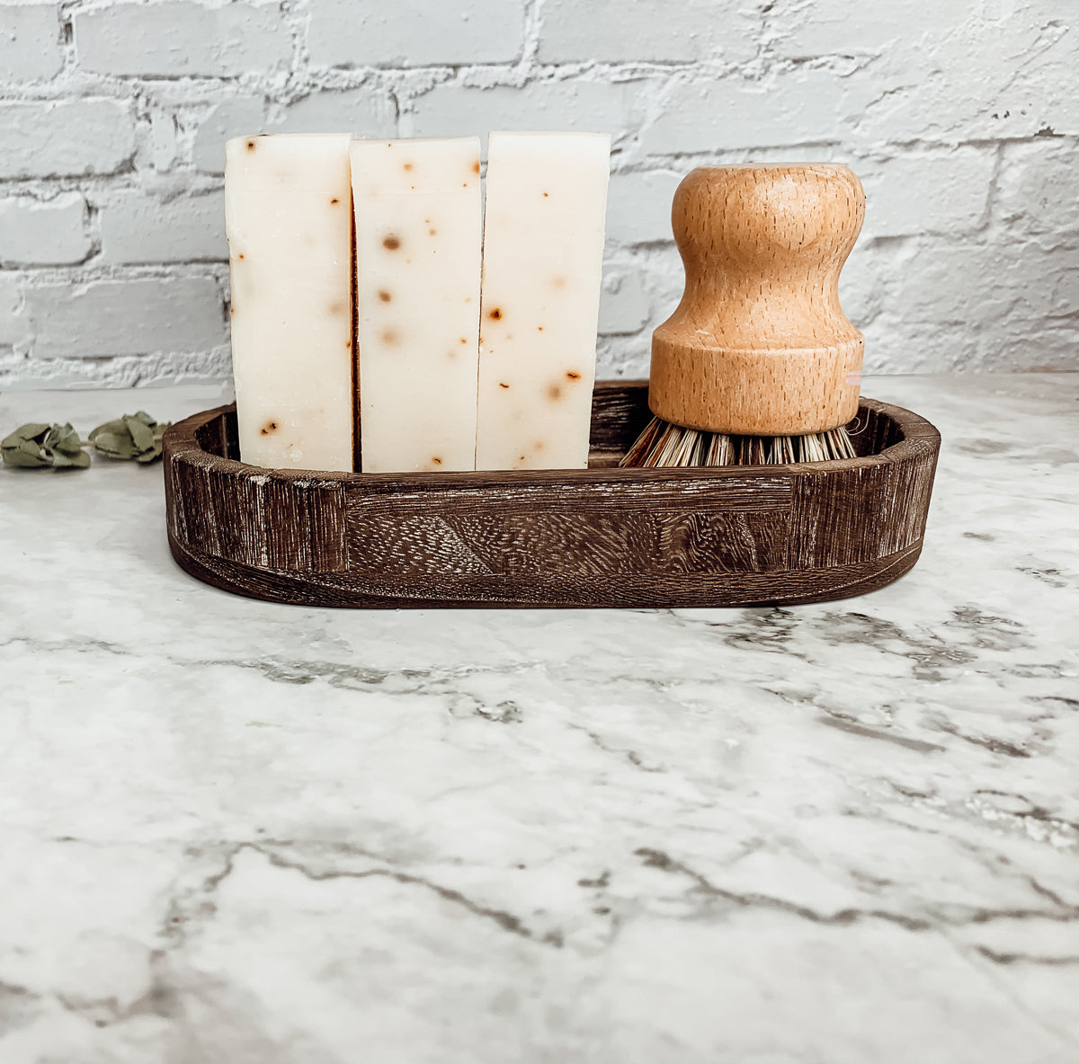 A bar of Tea Tree Mint soap featuring a blend of tea tree oil and peppermint leaves, showcasing its natural colors and texture.