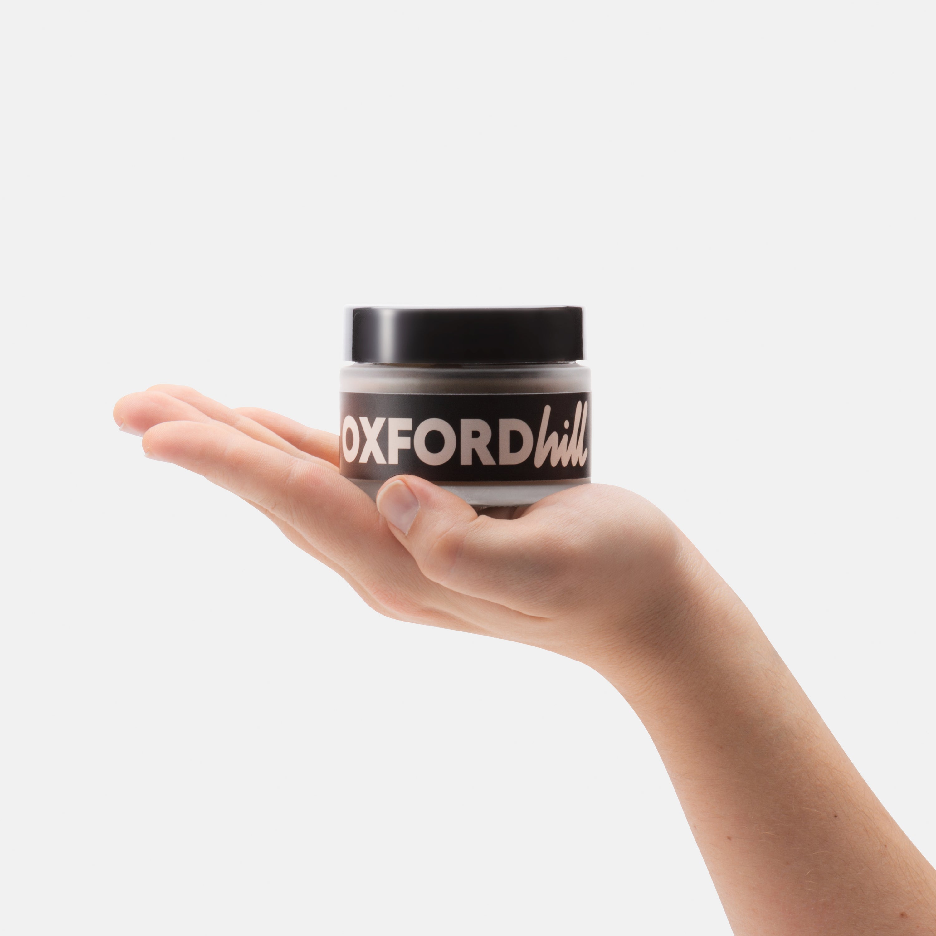 Hand holding a small jar.