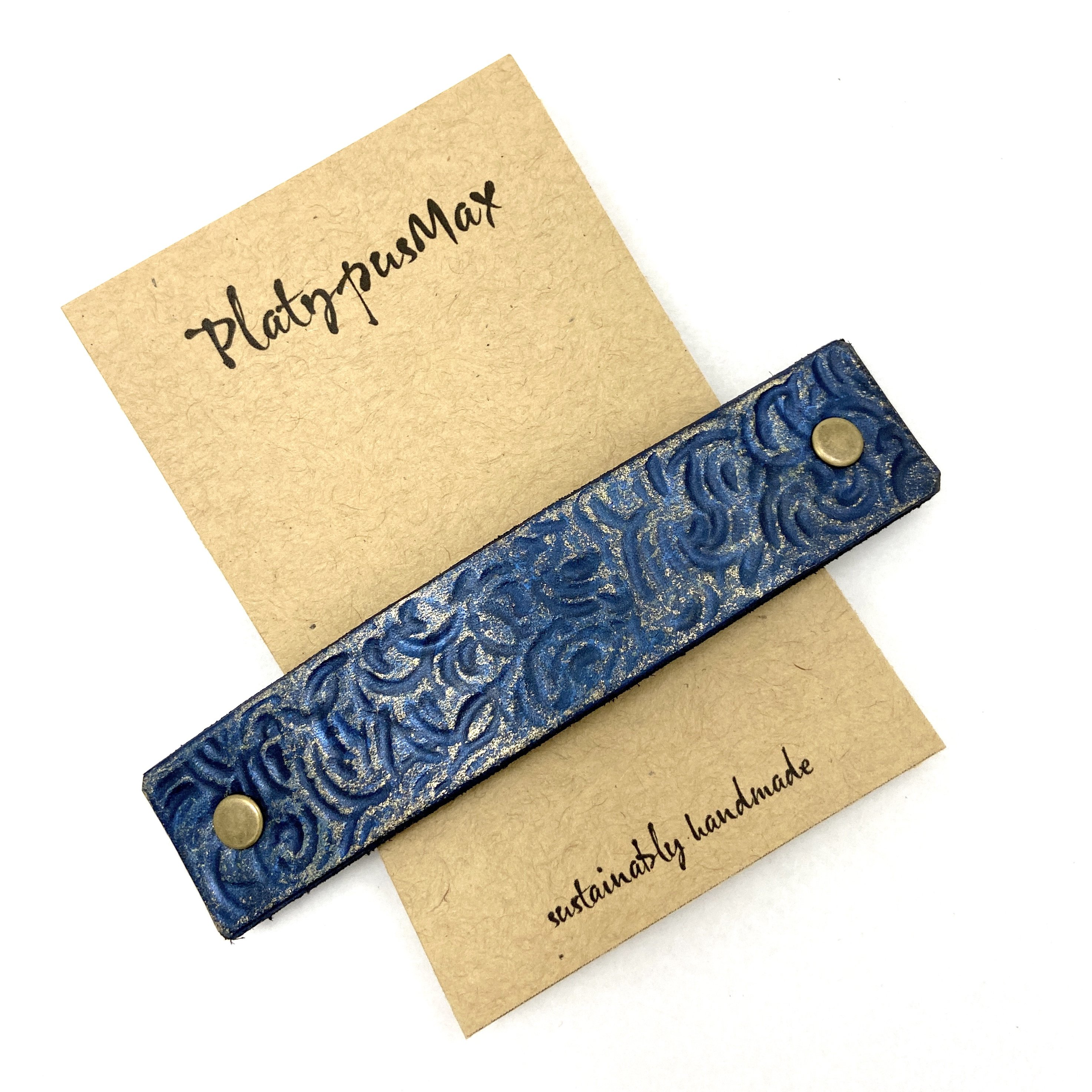 Lapis blue and gold leather barrette featuring rustic spiral texture, perfect for stylish hairdos.