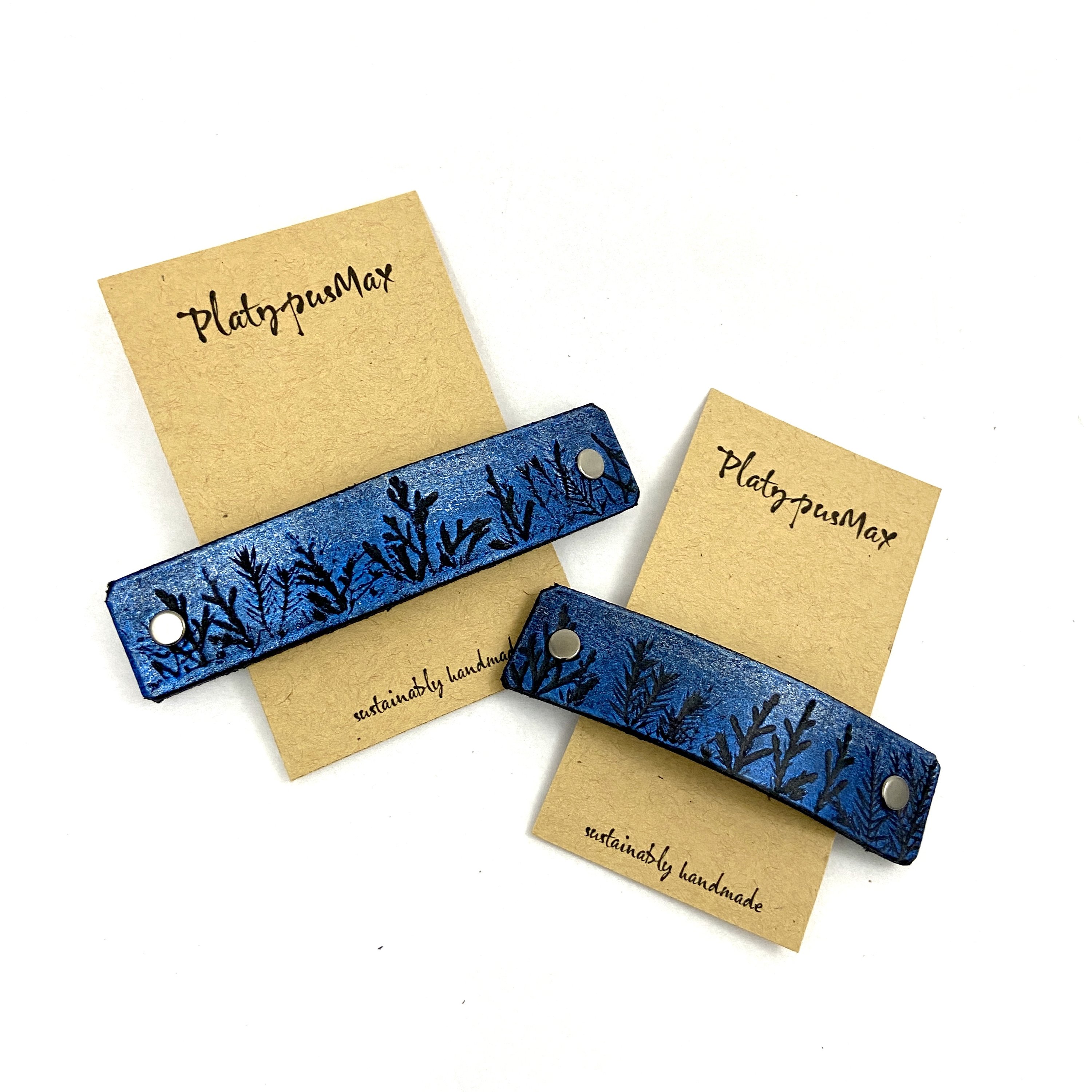 Tiny Forest leather hair barrette featuring blue and silver shimmer with tree silhouettes, handcrafted from remnant leather.