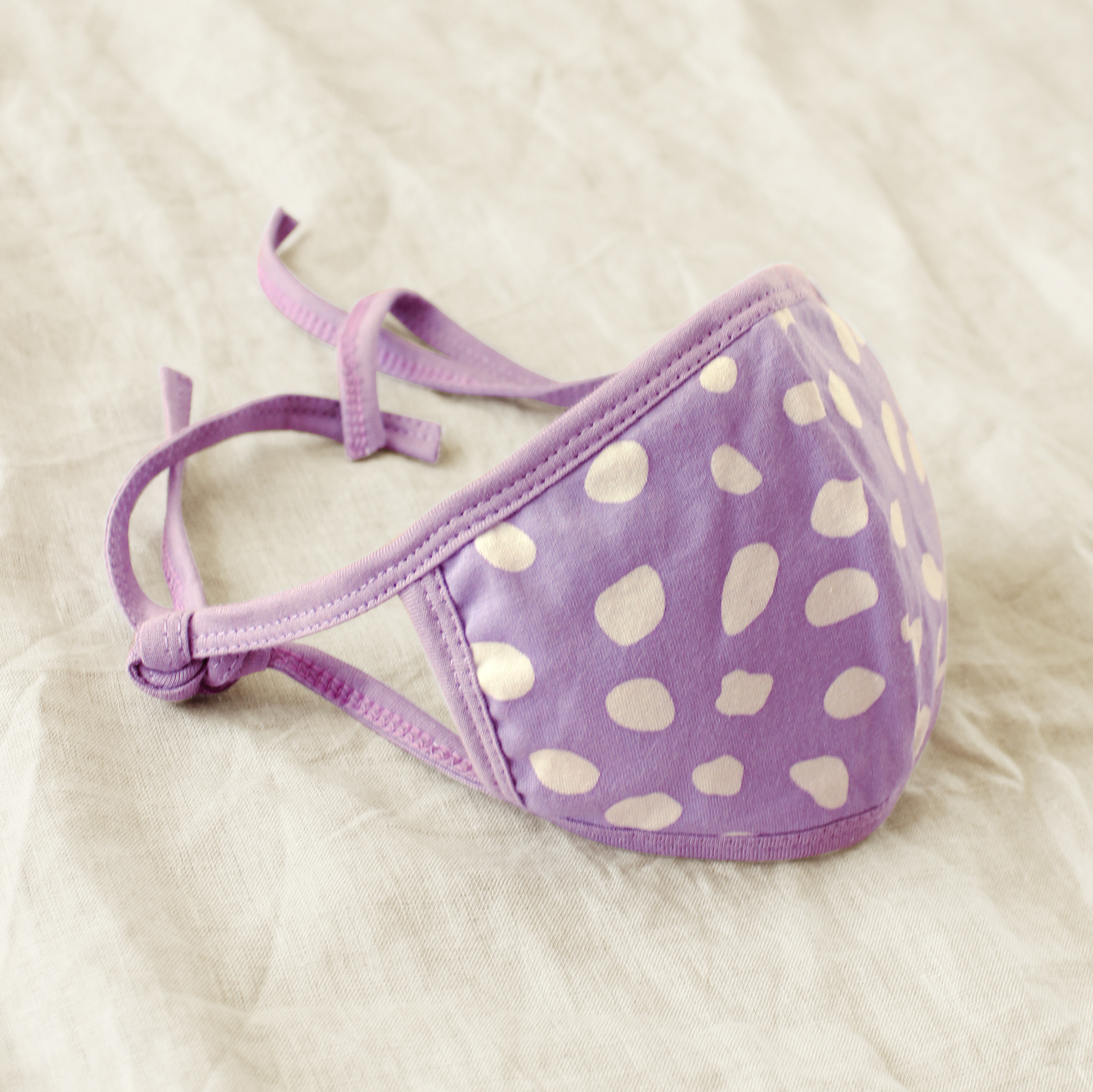 ARNOLDI 3-ply Organic Cotton Face Mask in Lilac, featuring a unique floral pattern and adjustable straps for a comfortable fit.