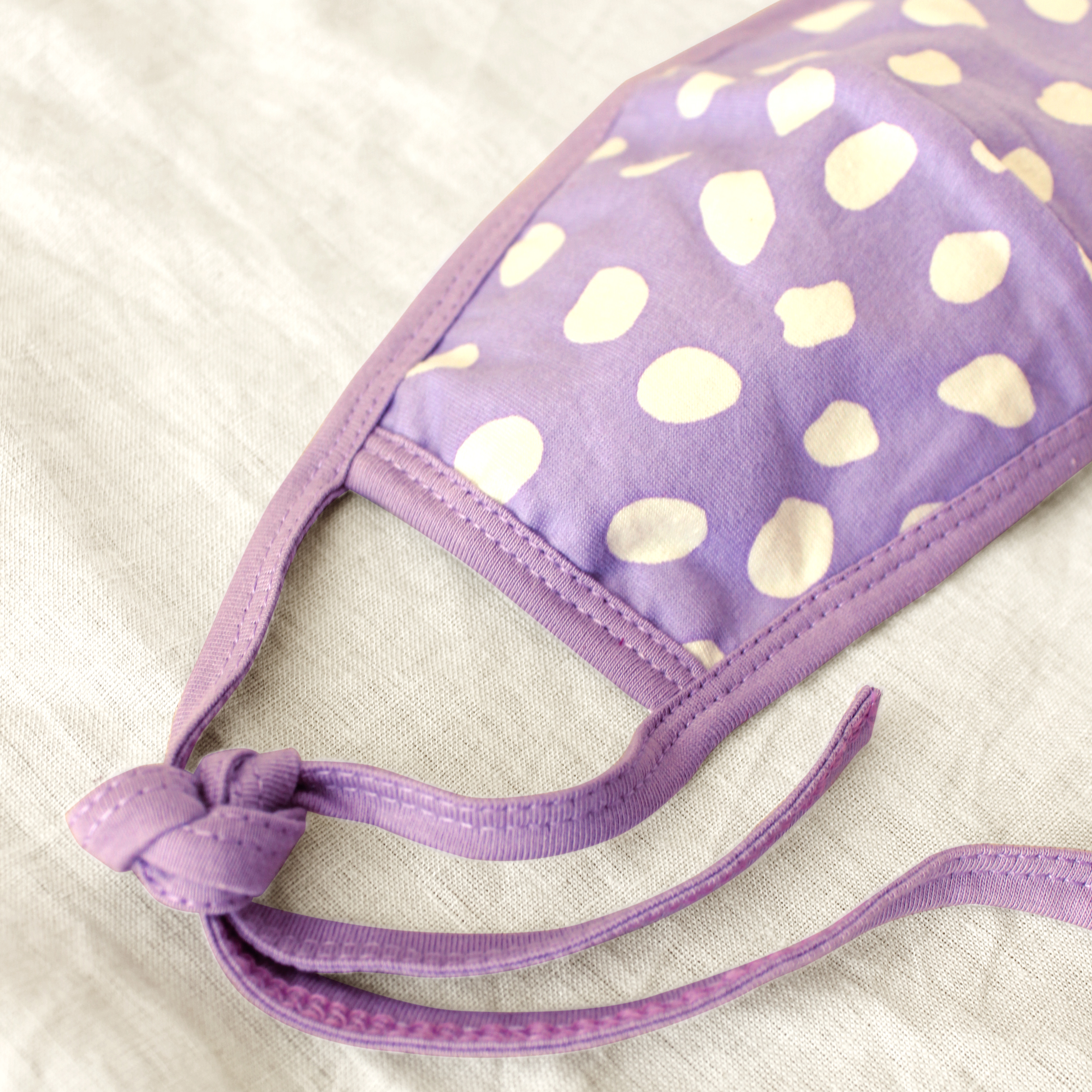 ARNOLDI 3-ply Organic Cotton Face Mask in Lilac, featuring a unique floral pattern and adjustable straps for a comfortable fit.