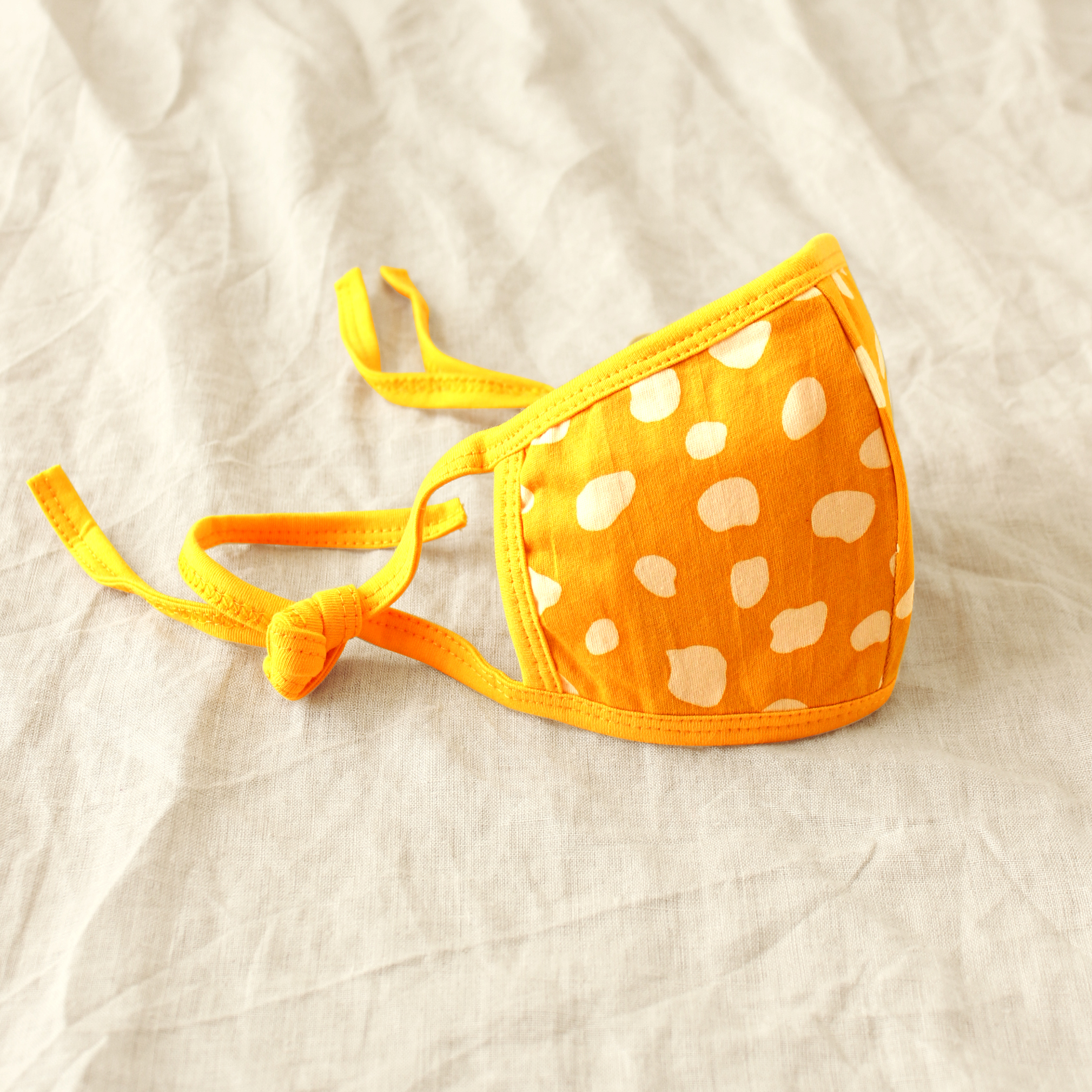 ARNOLDI 3ply Organic Cotton Face Mask in Golden Saffron, featuring a joyful design and waterproof filter, showcasing the unique Arnoldi pattern.