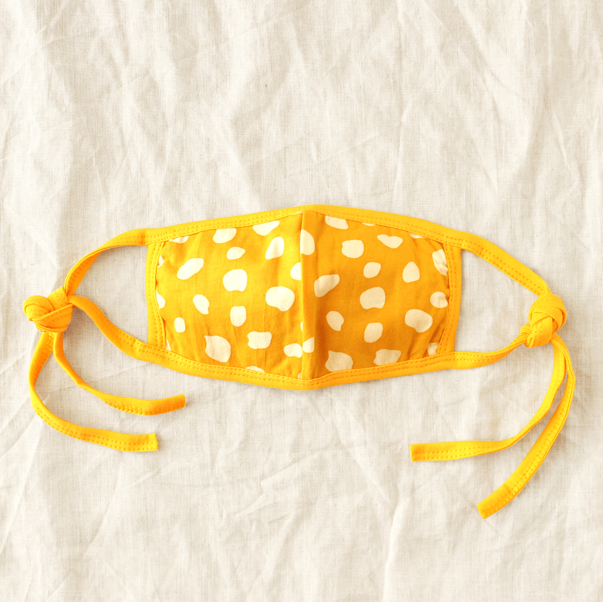 ARNOLDI 3ply Organic Cotton Face Mask in Golden Saffron, featuring a joyful design and waterproof filter, showcasing the unique Arnoldi pattern.