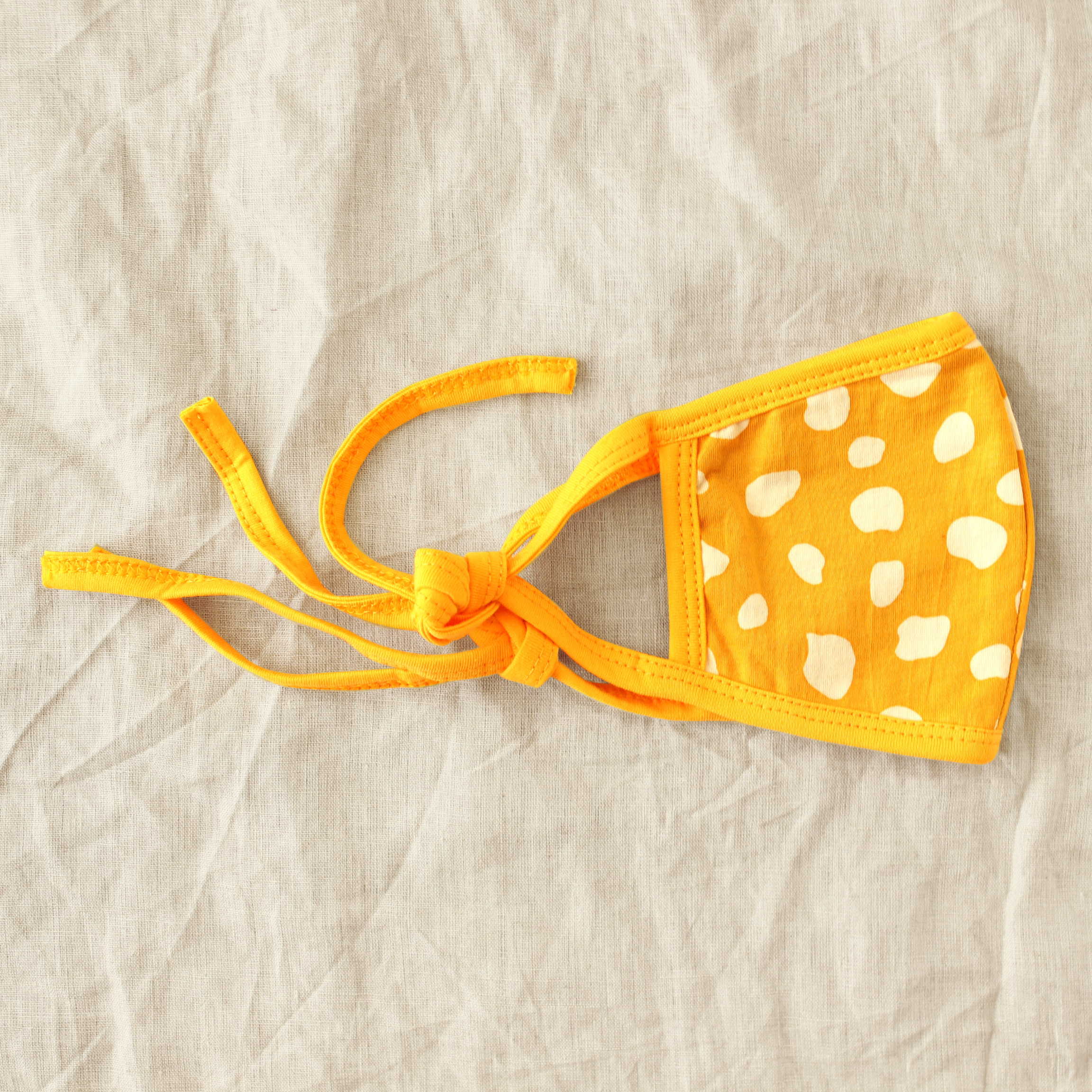 ARNOLDI 3ply Organic Cotton Face Mask in Golden Saffron, featuring a joyful design and waterproof filter, showcasing the unique Arnoldi pattern.