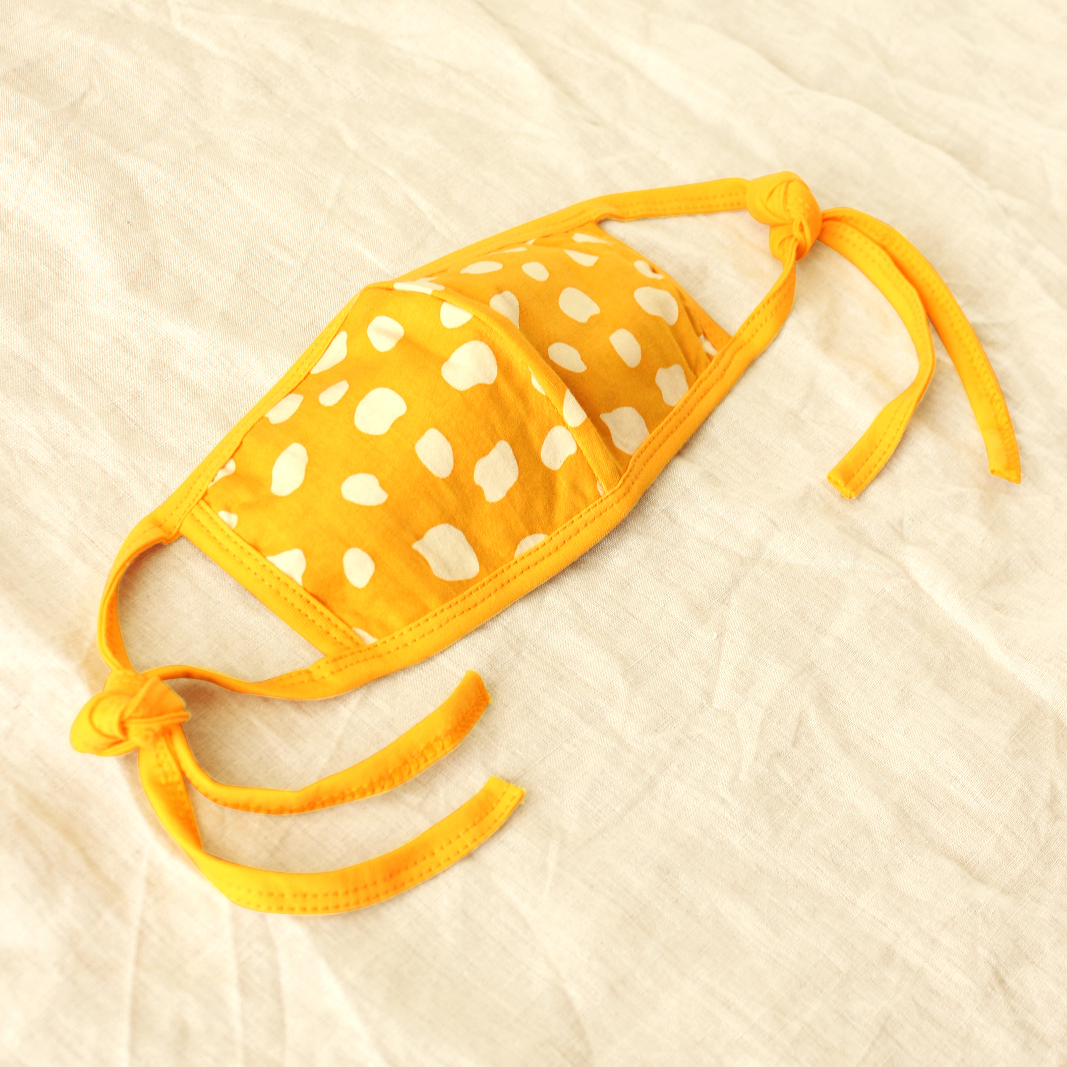 ARNOLDI 3ply Organic Cotton Face Mask in Golden Saffron, featuring a joyful design and waterproof filter, showcasing the unique Arnoldi pattern.