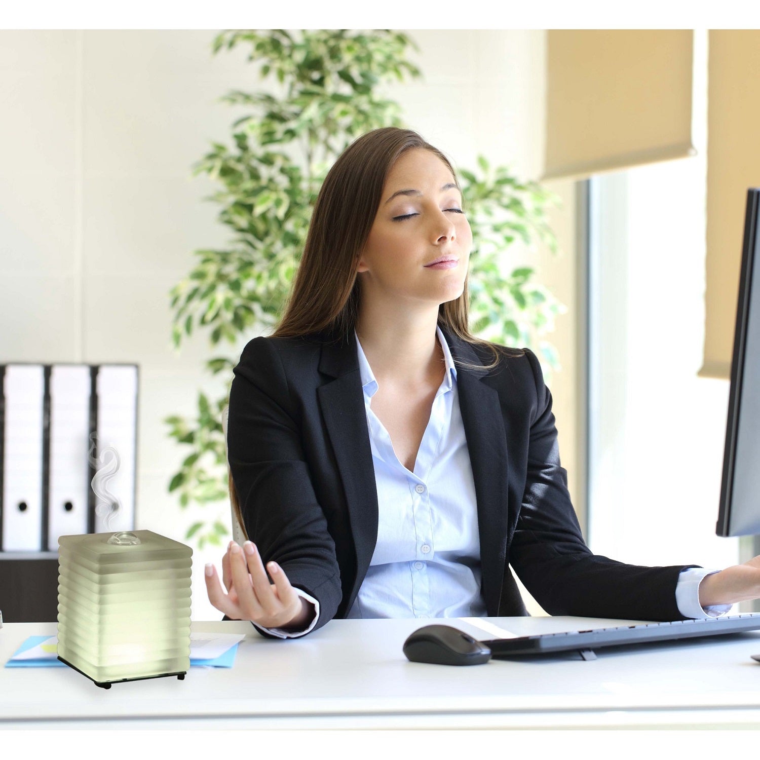 A stylish glass essential oil diffuser with a warm white LED light, designed for aromatherapy and home decor.