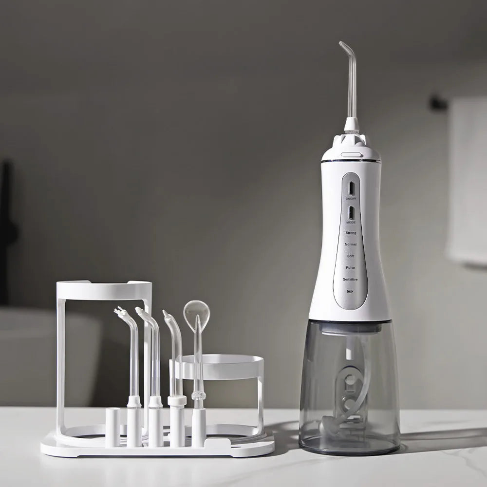 Portable Oral Irrigator Water Flosser with 5 modes and 350ML water tank, showcasing its sleek design and included nozzles.