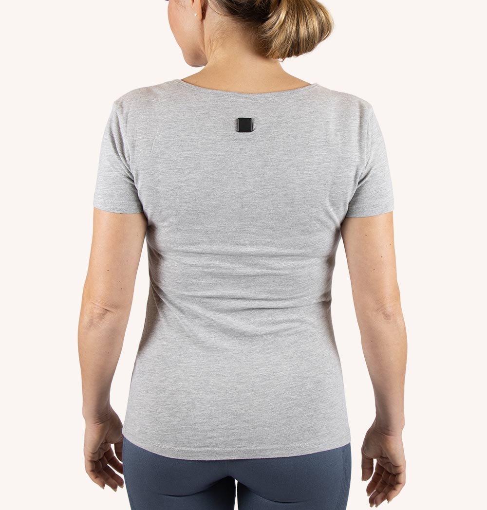 Vibe Posture Digital Sensor attached to a shirt, showcasing its compact design and magnetic closure.