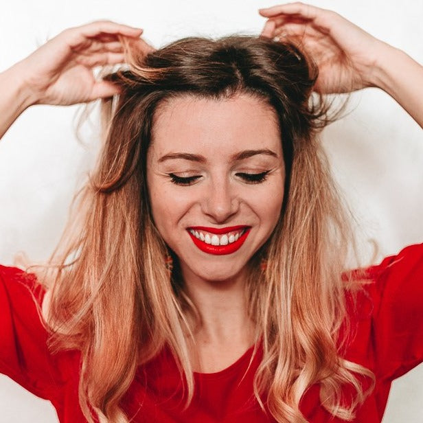 03 Rossetto 'Sunset in Colorland' lipstick showcasing a vibrant warm red shade in a stylish marshmallow-like packaging.