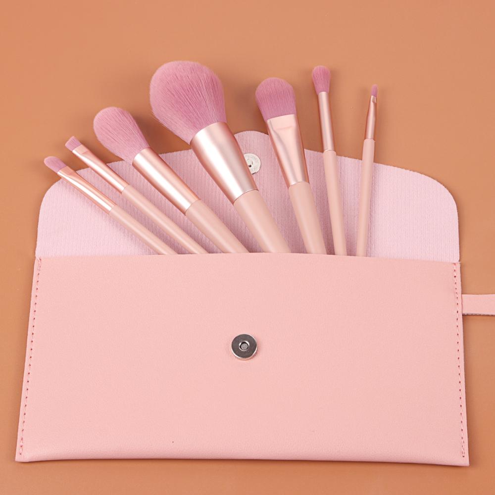 A stylish 12-piece nude pink makeup brush set featuring various brushes for flawless makeup application, including eyelash curlers and eyeshadow brushes.