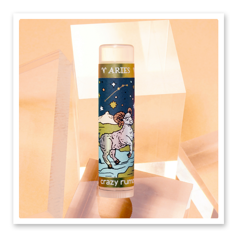 A vibrant product tube representing Aries, featuring fresh citrus and aromatic spice flavors, elegantly packaged in a gift box.
