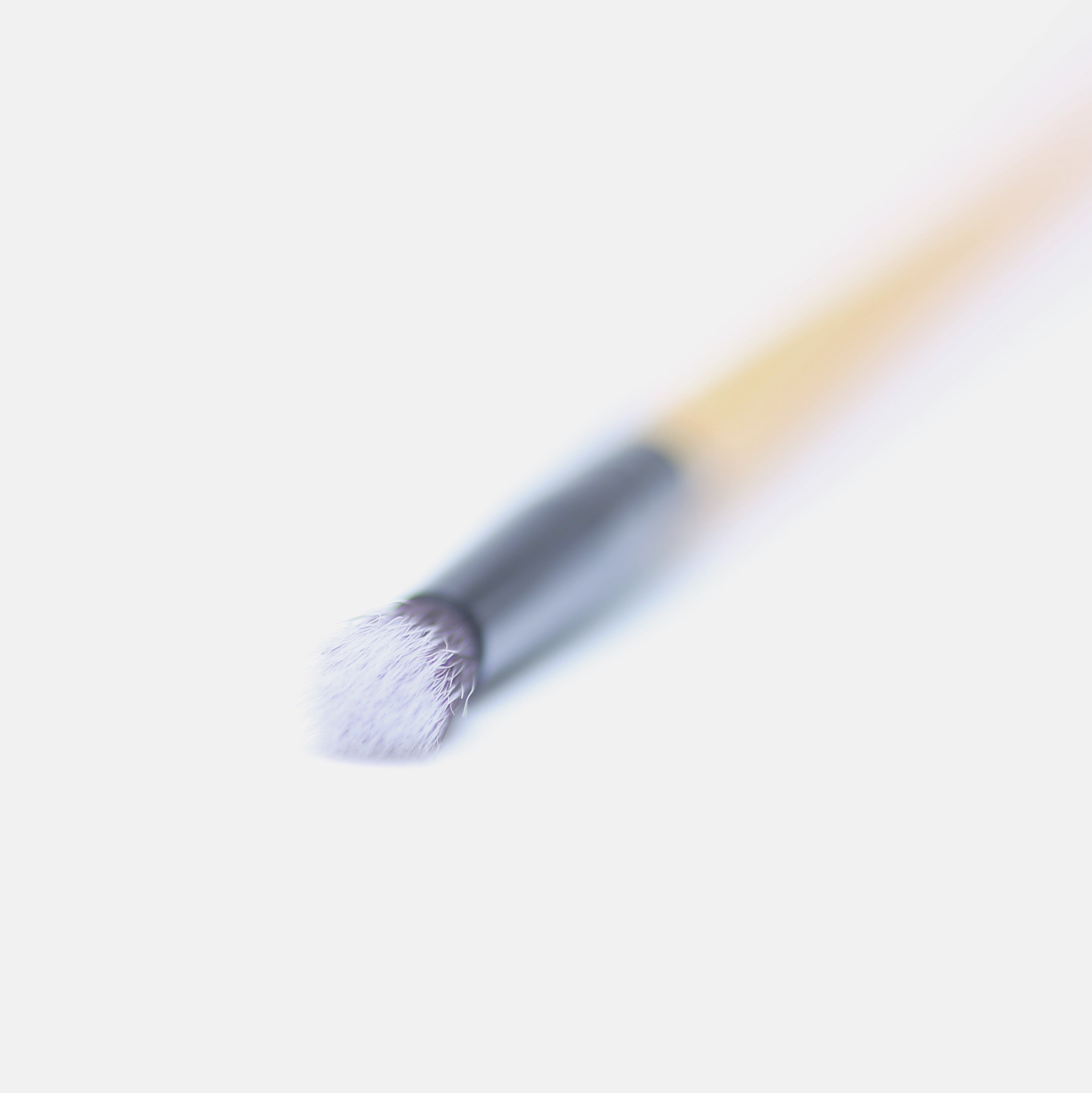 A close-up of a vegan detailing brush with a bamboo handle and soft synthetic bristles, ideal for precise makeup application.