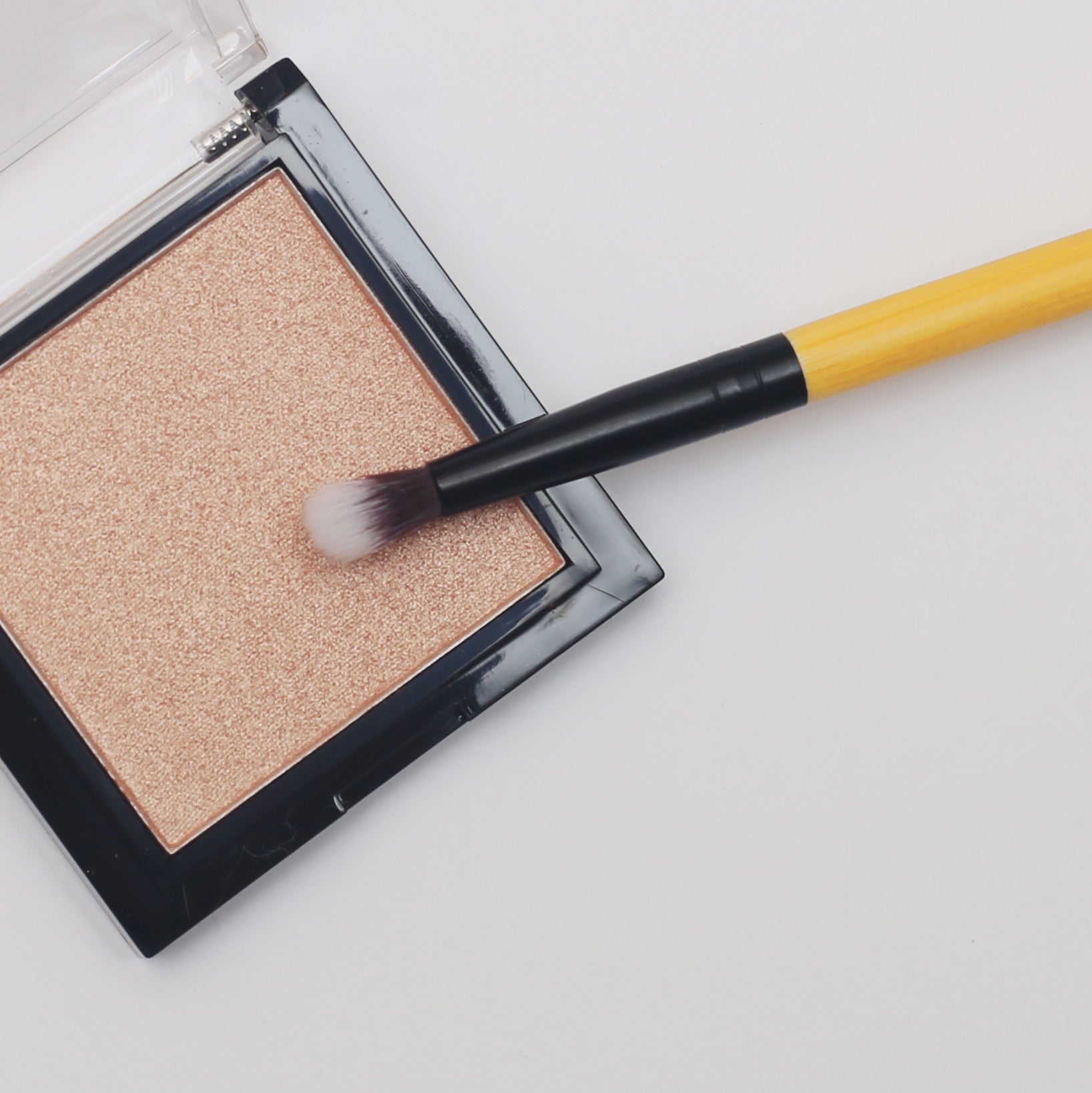 A close-up of a vegan detailing brush with a bamboo handle and soft synthetic bristles, ideal for precise makeup application.