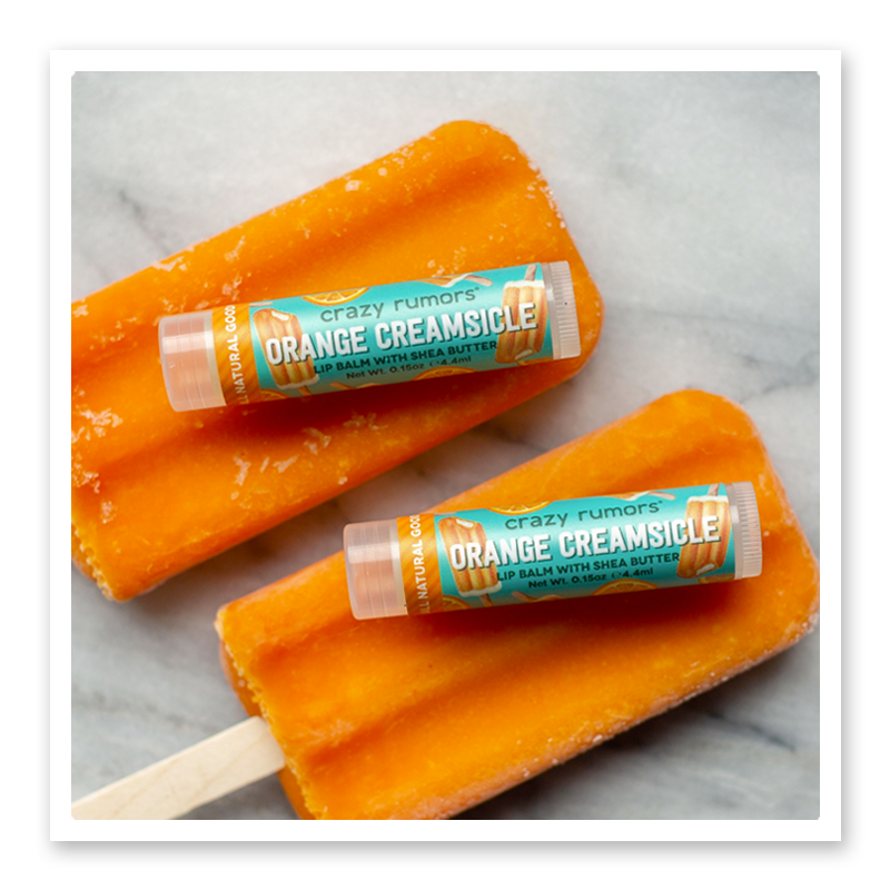 A vibrant tube of Orange Creamsicle, showcasing its fruity orange and creamy vanilla design, perfect for skincare enthusiasts.