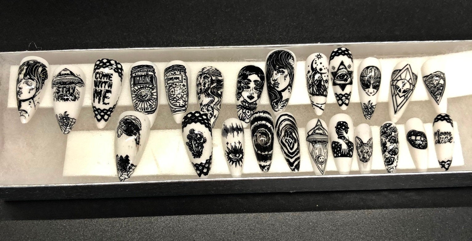 A set of 24 alien-themed false nails with various designs, perfect for press-on application and includes glue stickers.