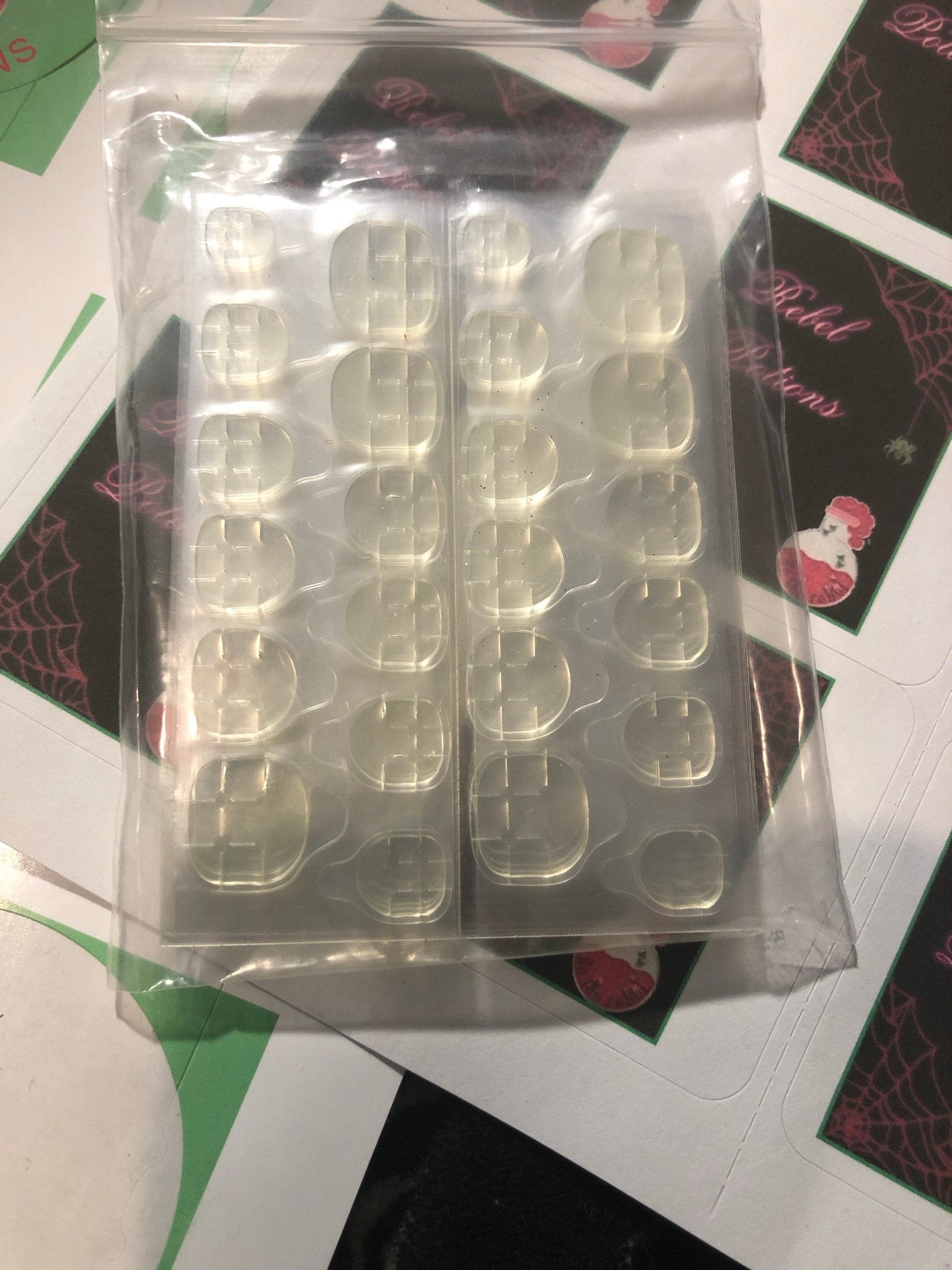 A set of 24 alien-themed false nails with various designs, perfect for press-on application and includes glue stickers.