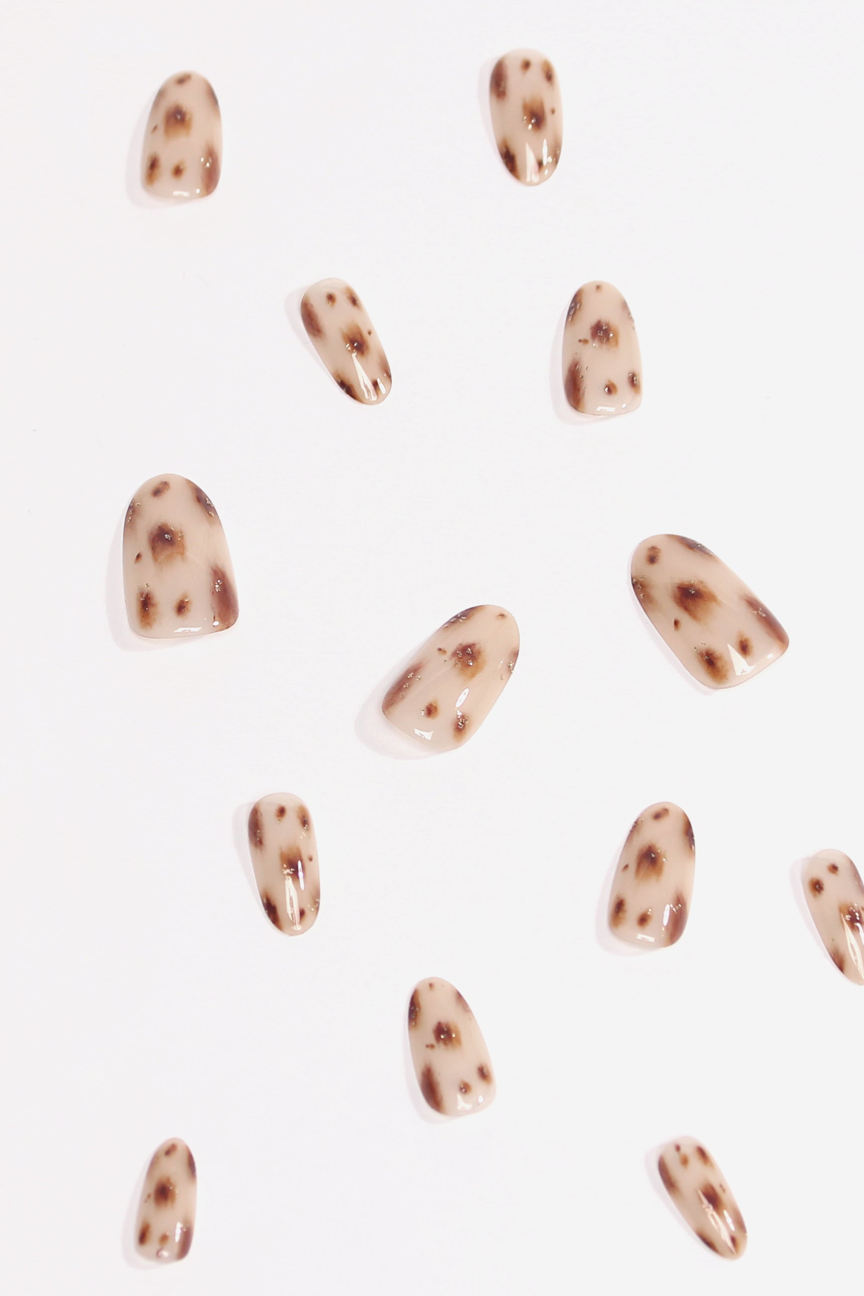 Cheetah Glam press-on nails featuring a nude base with brown and tan cheetah spots and subtle glitter accents.