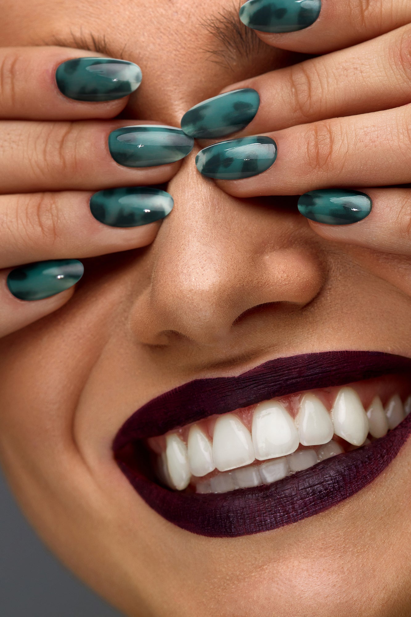 Emerald Amber press-on nails featuring a peacock green base with amber-inspired patterns, showcasing a glossy finish.