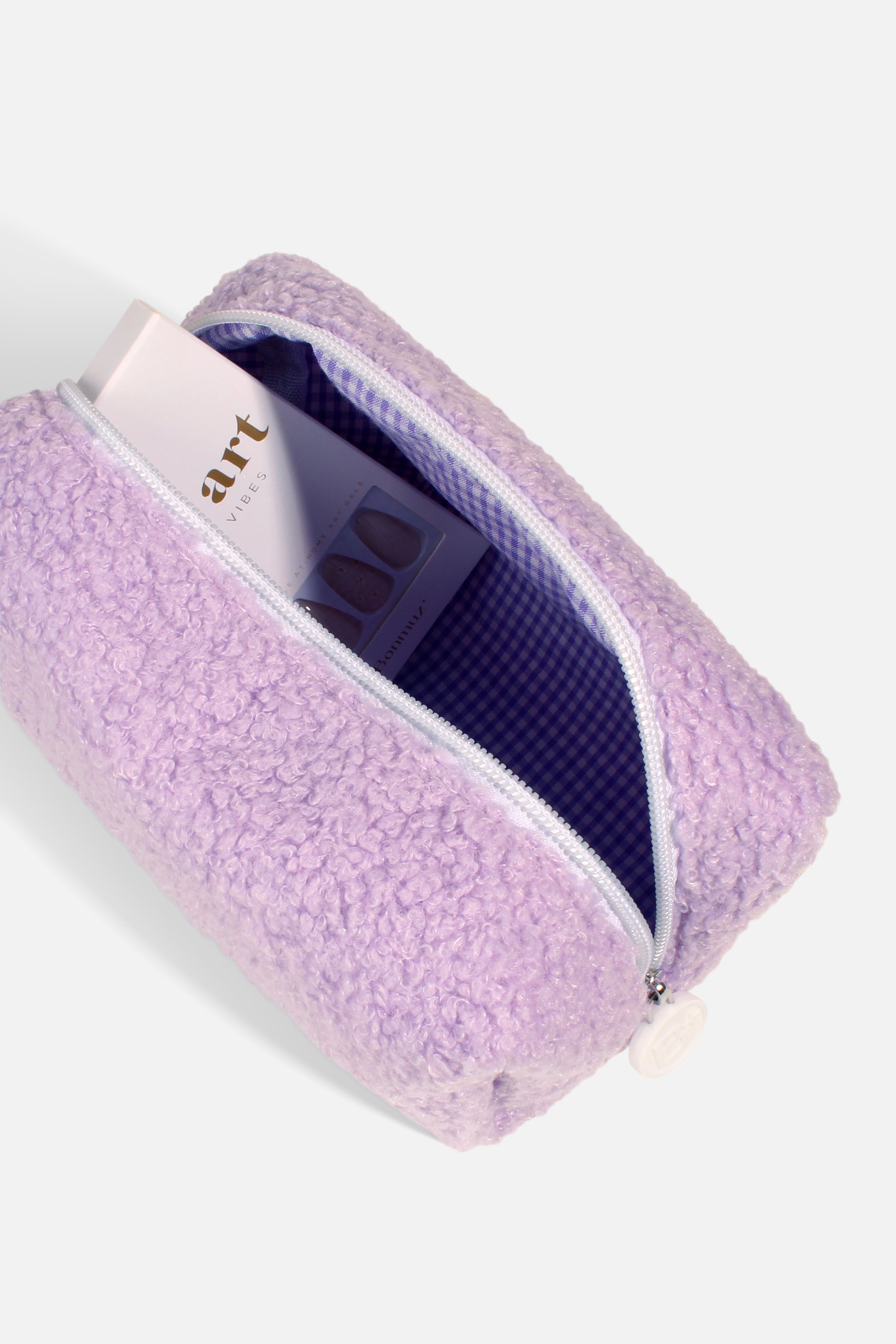 A soft and fluffy Polar Puff Pouch in cream and pastel purple, featuring a chic checkered interior design.