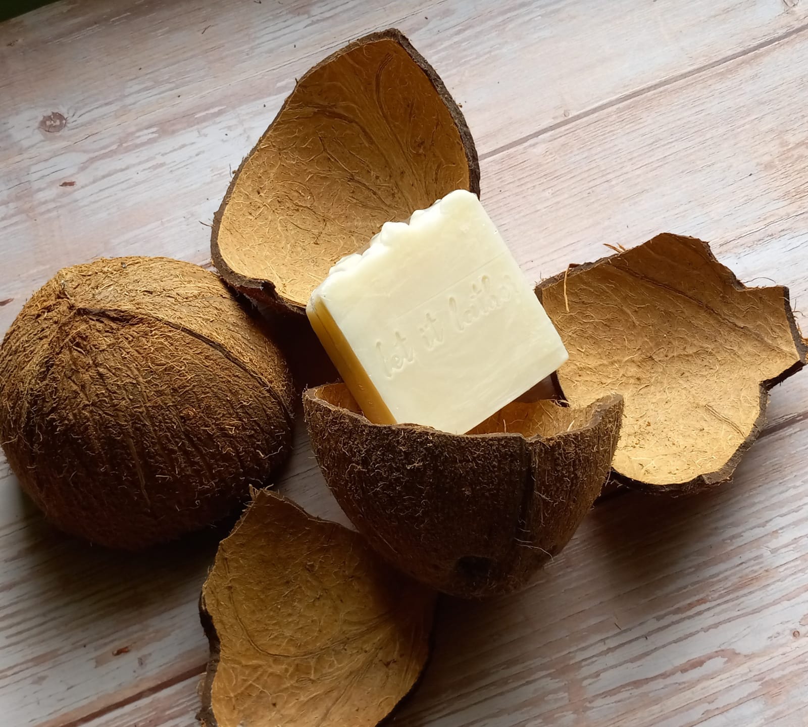 A bar of 100% Handmade Coconut Milk Bath Soap with a creamy texture, showcasing its natural ingredients and luxurious lather.