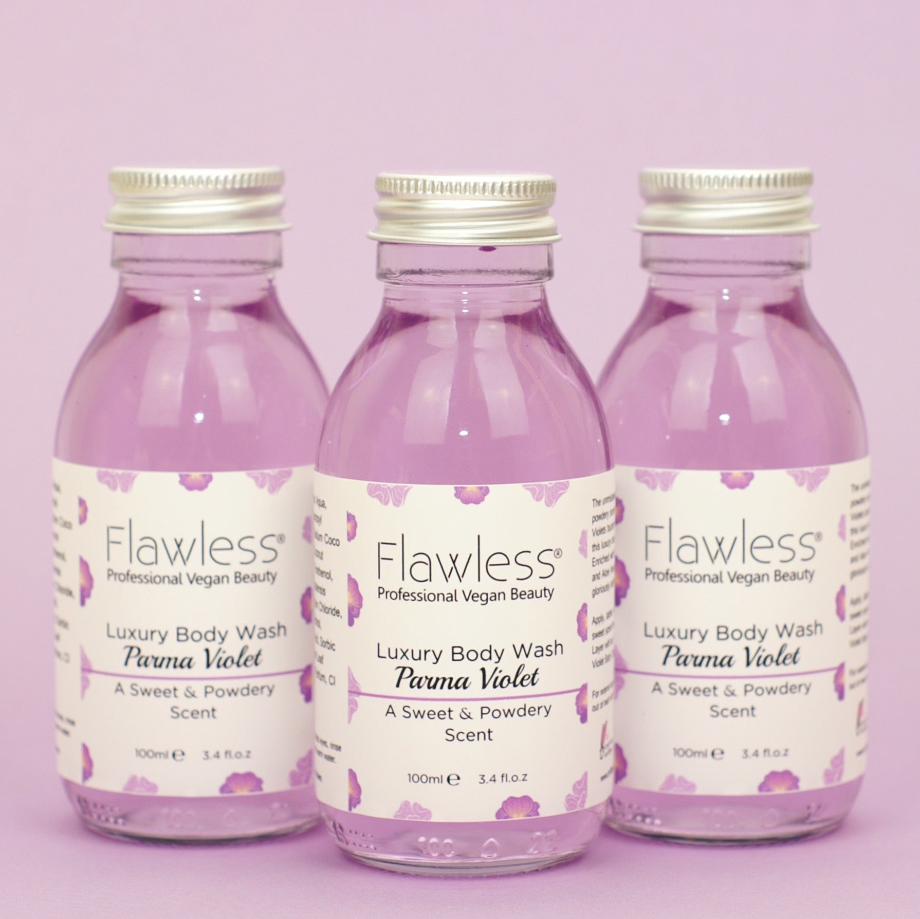 A luxurious Parma Violet body wash in a recycled glass bottle with an aluminum lid, showcasing its creamy texture and vibrant color.