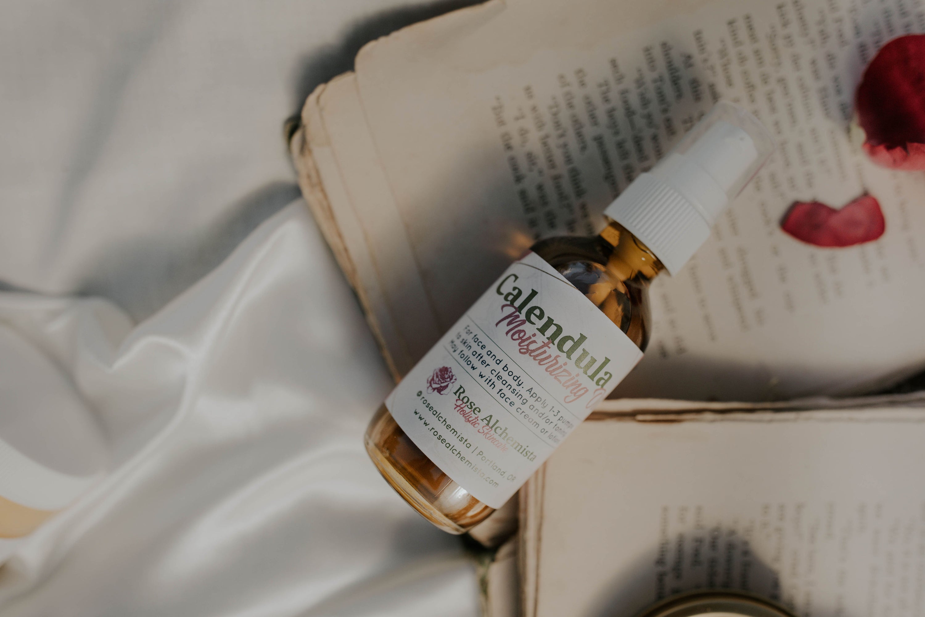 A 2oz glass bottle of Calendula Moisturizing Oil with a pump top, showcasing its natural ingredients and elegant design.