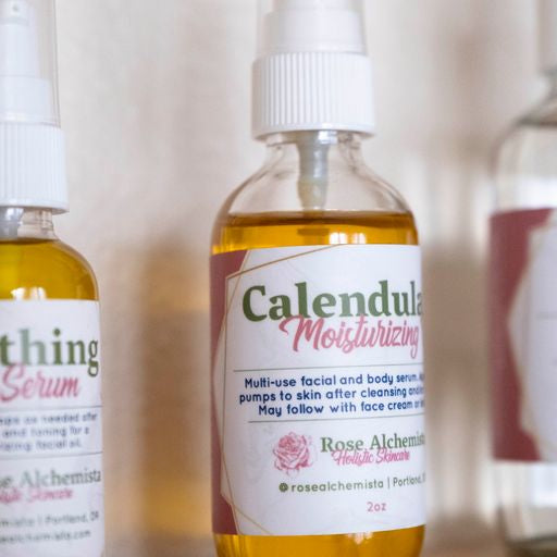 A 2oz glass bottle of Calendula Moisturizing Oil with a pump top, showcasing its natural ingredients and elegant design.