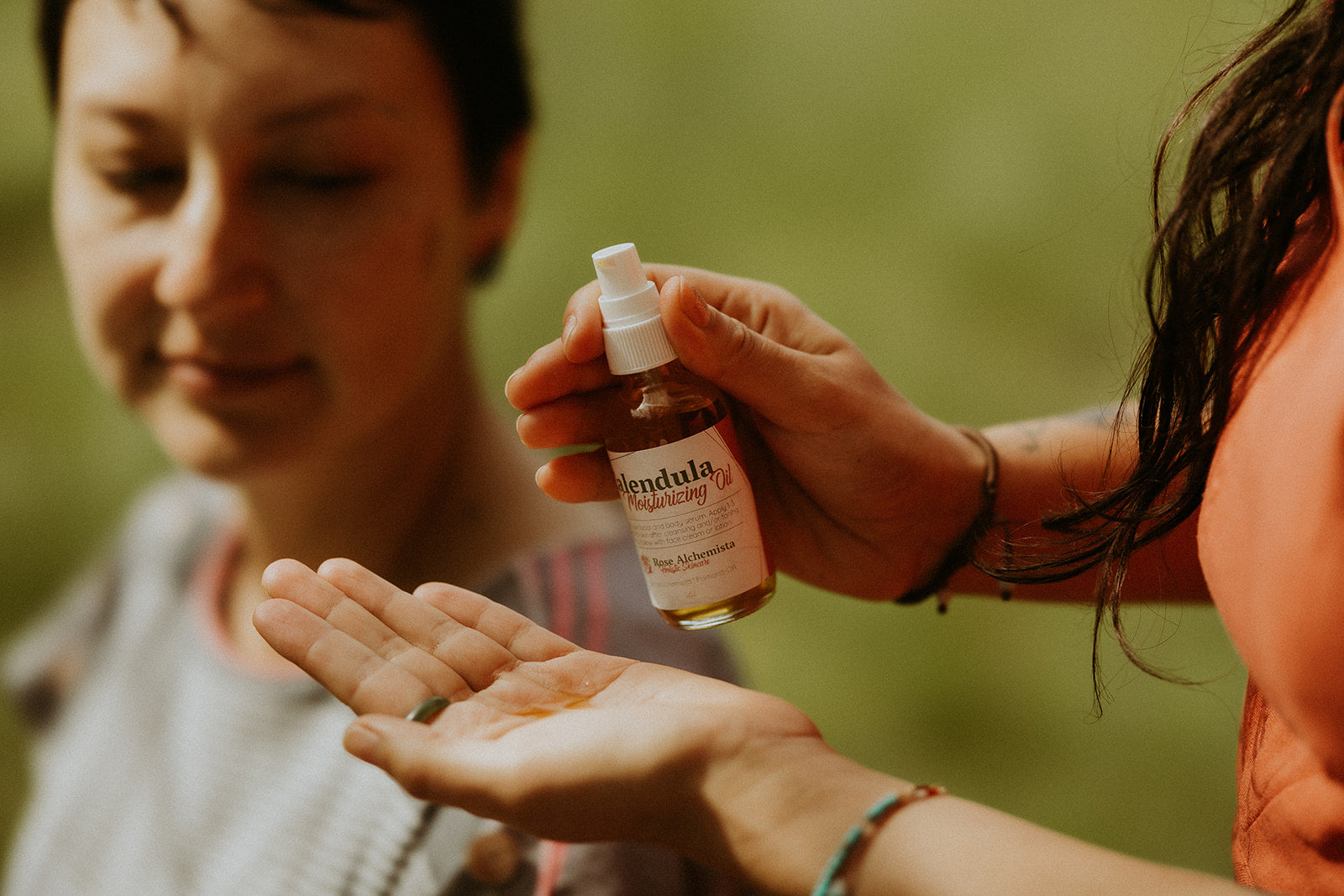 A 2oz glass bottle of Calendula Moisturizing Oil with a pump top, showcasing its natural ingredients and elegant design.