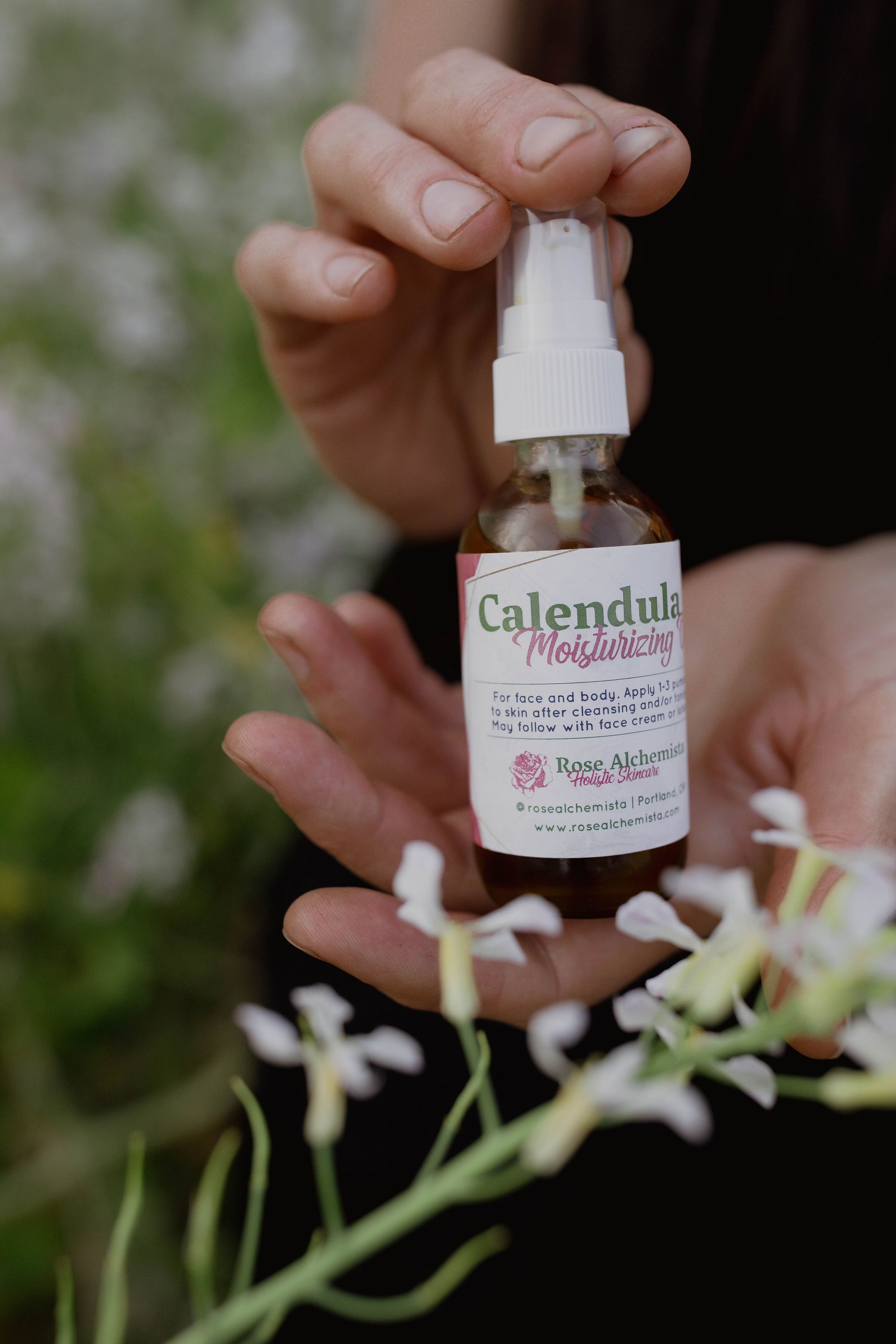 A 2oz glass bottle of Calendula Moisturizing Oil with a pump top, showcasing its natural ingredients and elegant design.